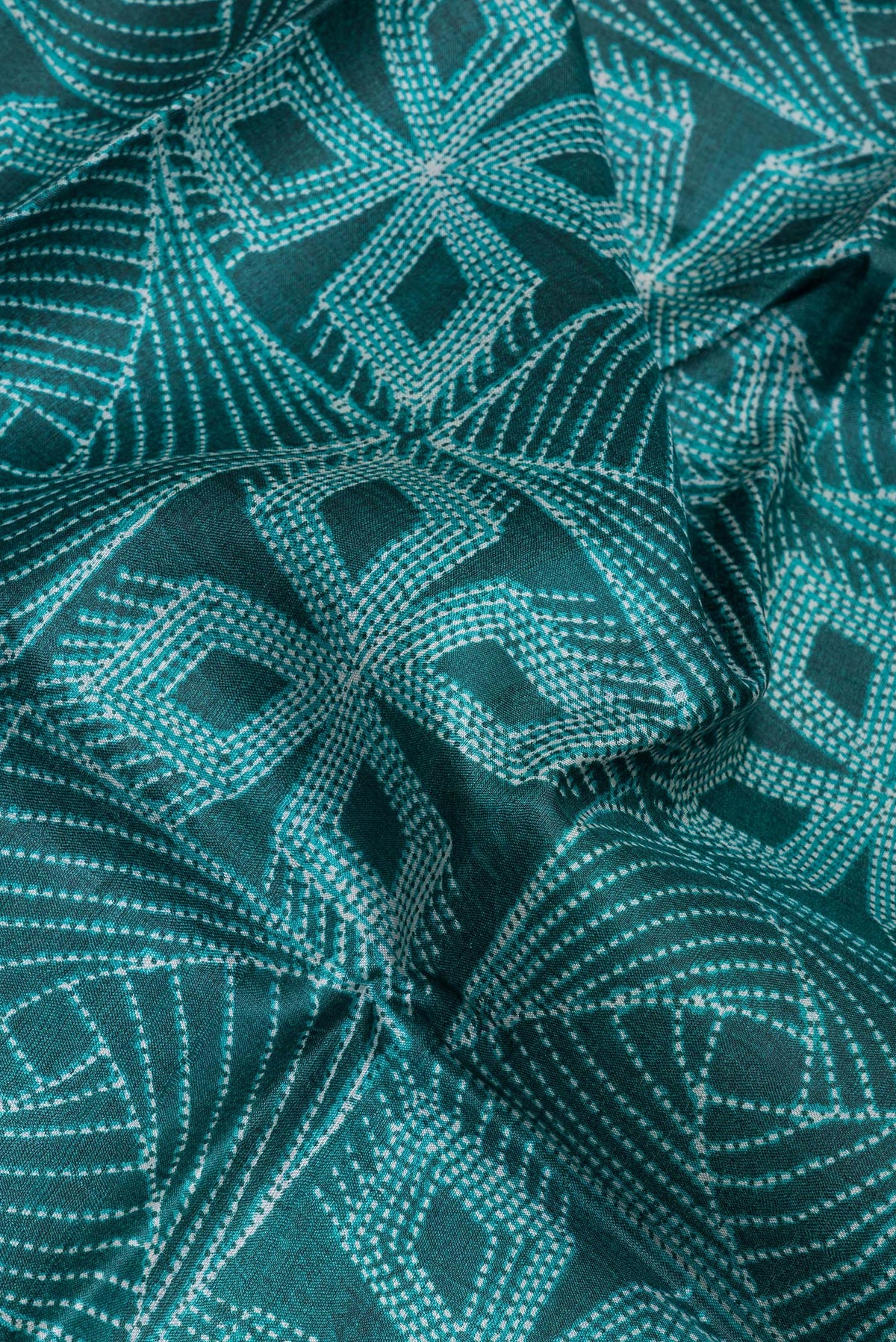 Close up of Bottle Green Tussar Silk Saree with Printed design on the body and Printed Border.  displaying folds