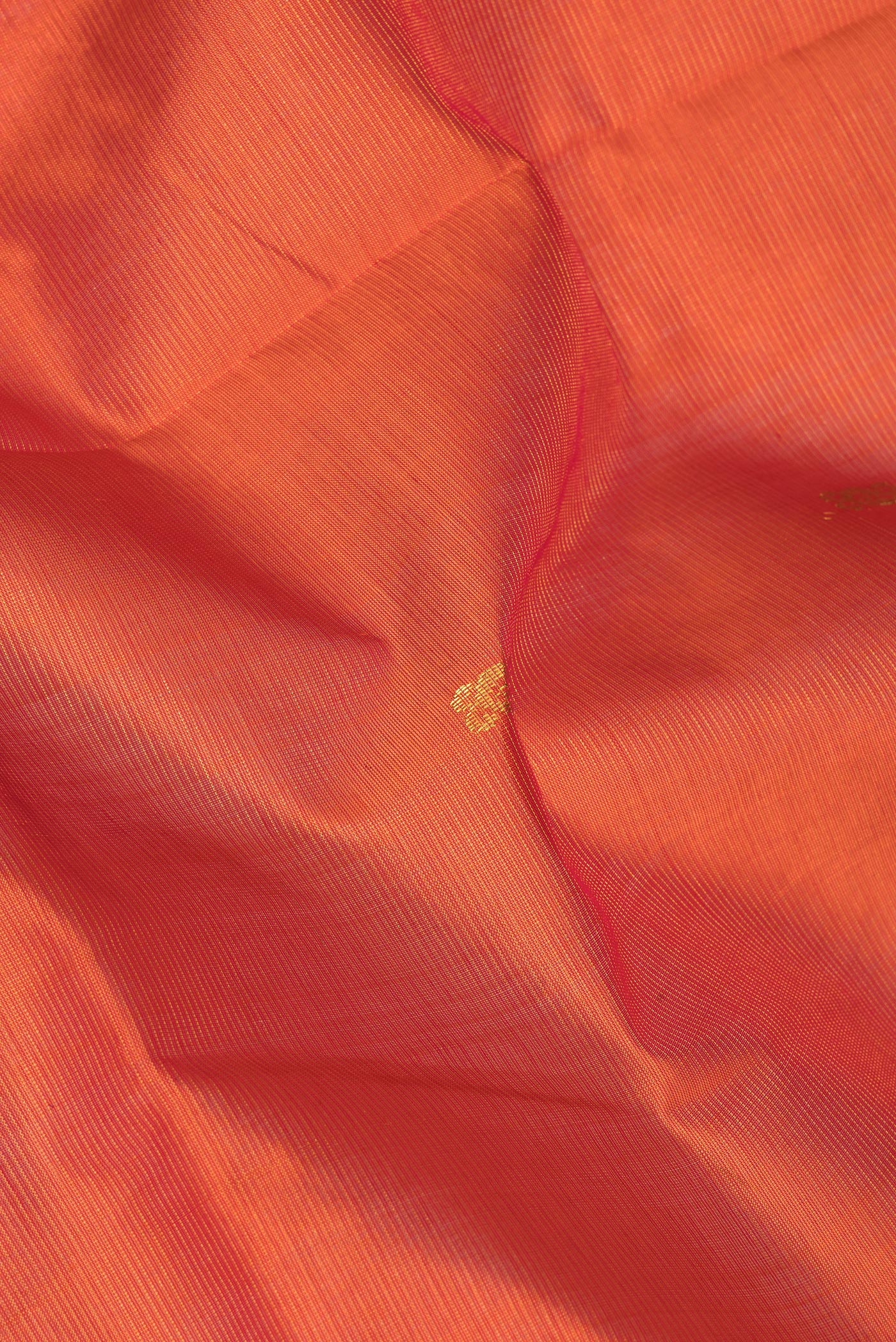 Close up of Orange Silk Cotton Saree with Zari Butta on the body and Zari Border.  displaying folds