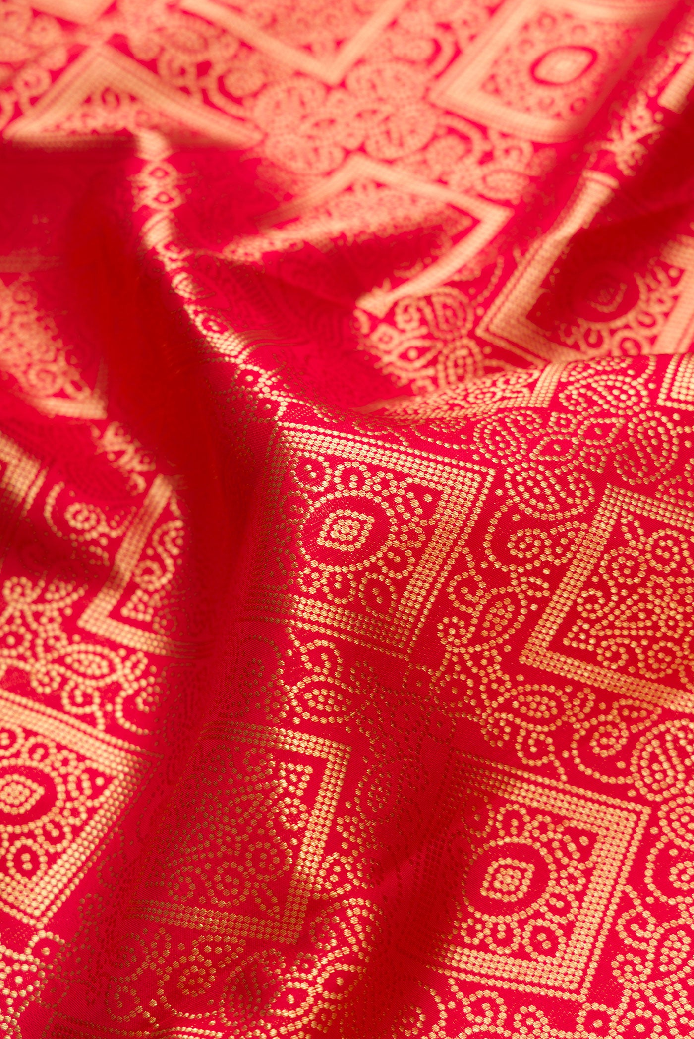 Close up of Red Dual Tone Kanchipuram Silk Saree with Zari Brocade on the body and Zari Border.  displaying folds