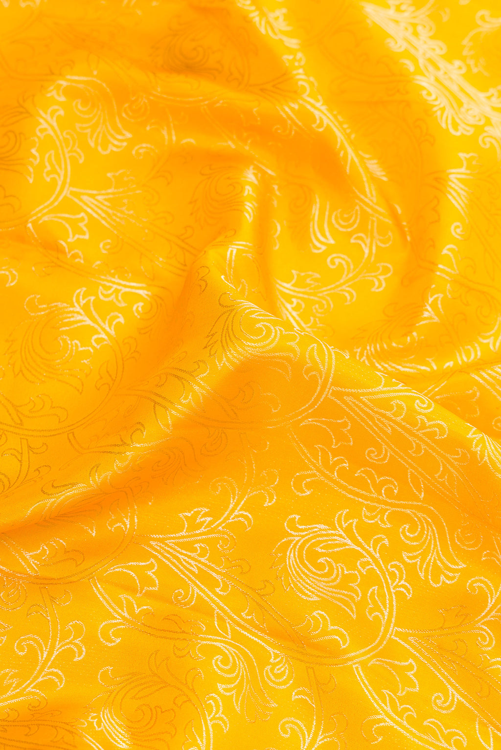Close up of Gold Dual Tone Kanchipuram Silk Saree with Zari Butta on the body and Zari Border.  displaying folds