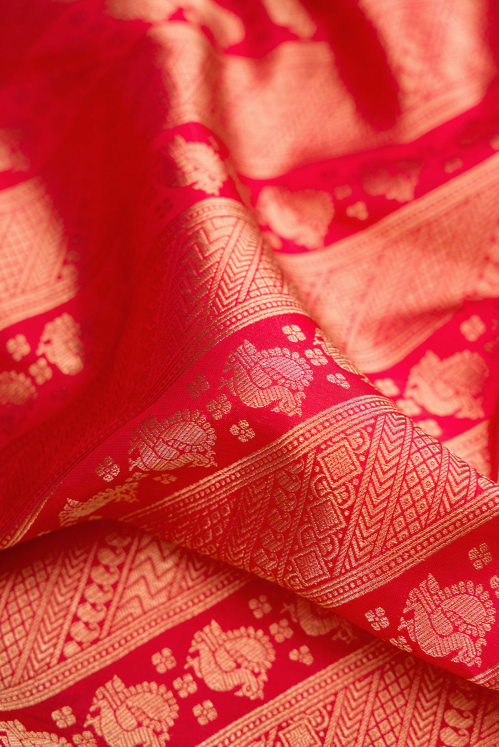 Close up of Red Kanchipuram Silk Saree with Zari Brocade on the body and Zari Border.  displaying folds