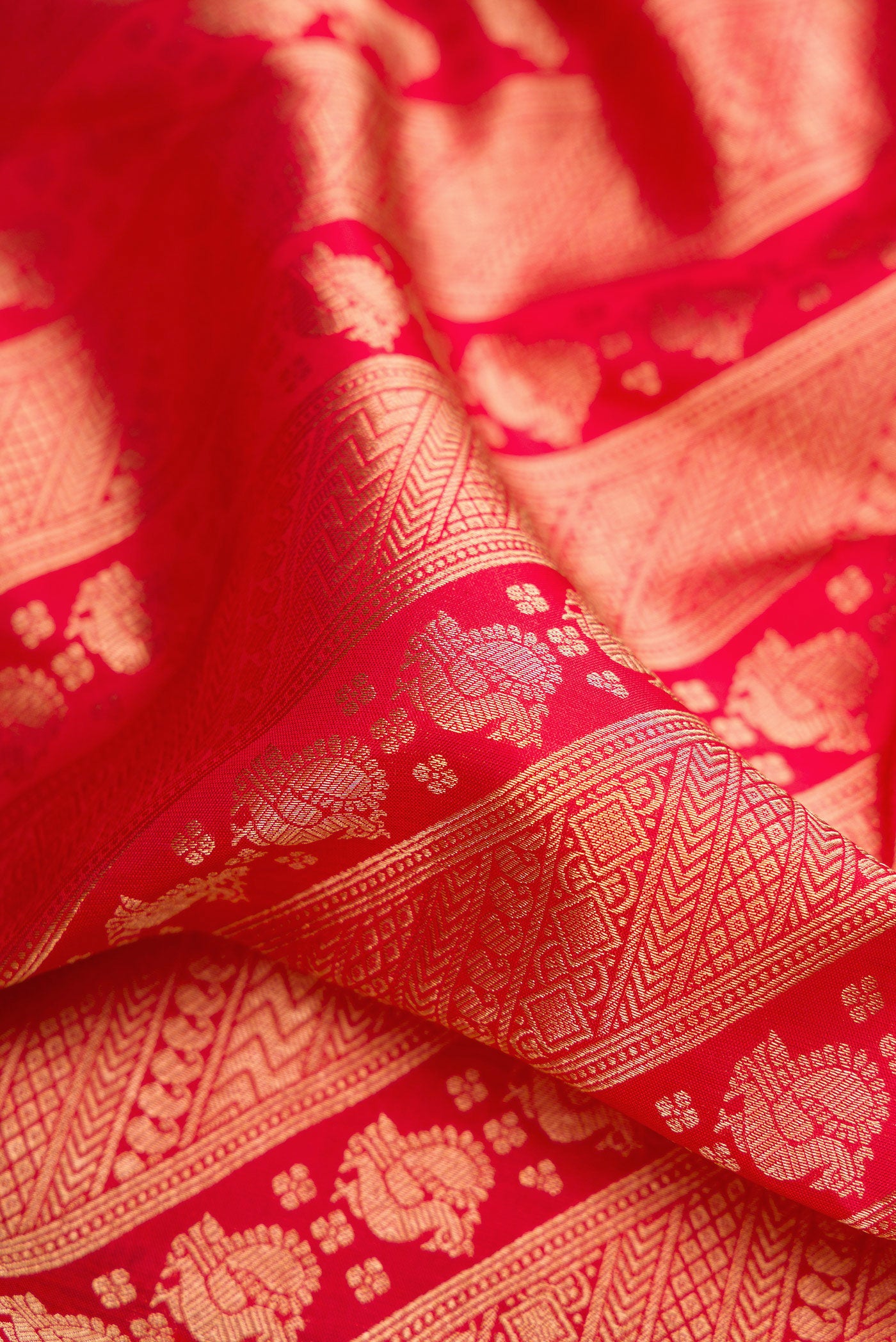 Close up of Red Kanchipuram Silk Saree with Zari Brocade on the body and Zari Border.  displaying folds