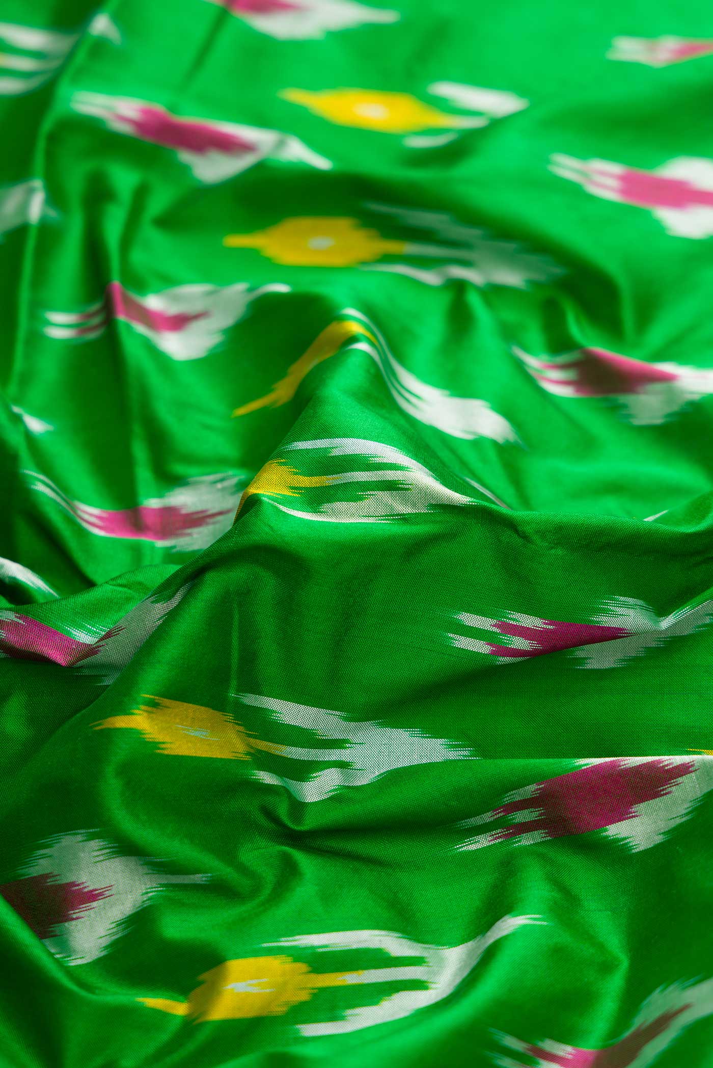Close up of Green Pochampally Silk Saree with Ikat Print on the body and Ikat Border displaying folds