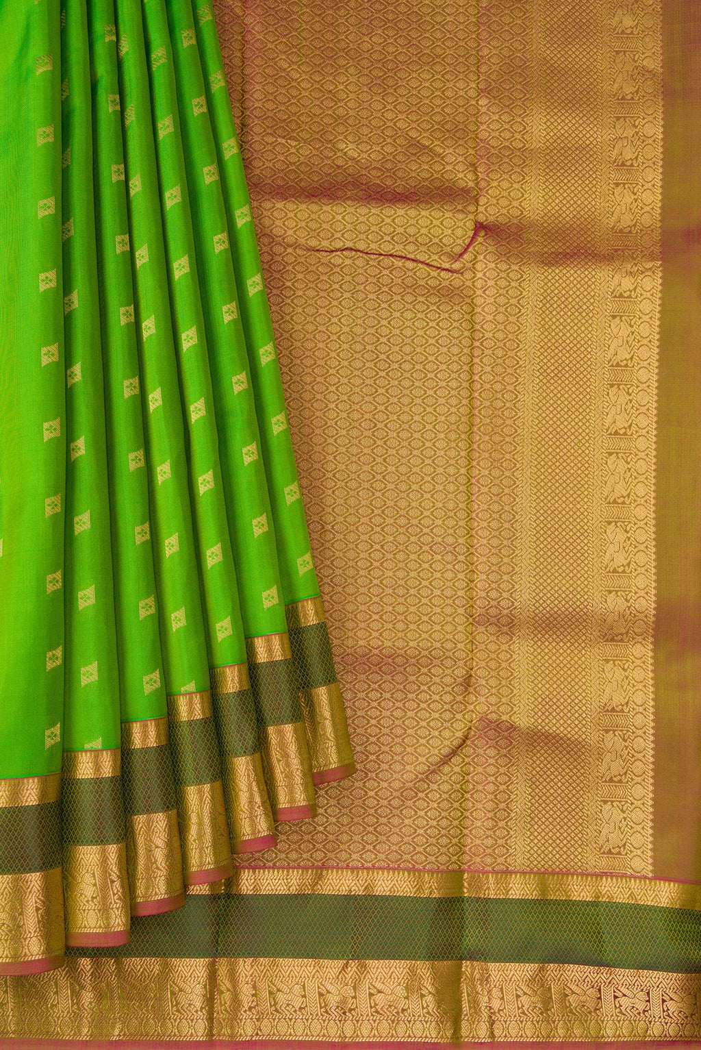 Pleats and pallu of Parrot Green Dual Tone Kanchipuram Silk Saree with Zari Butta on the body and Zari And Thread Border. 