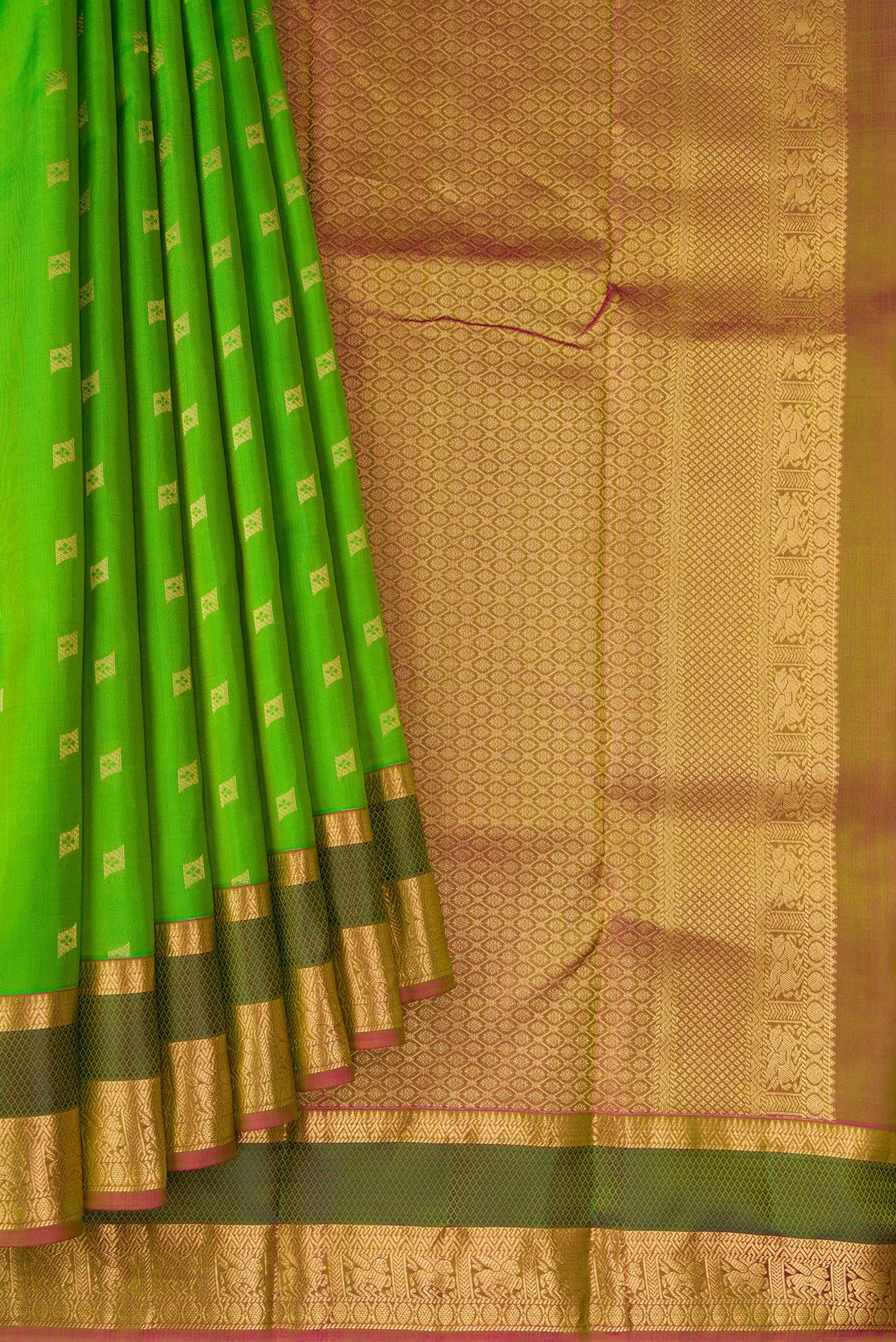 Pleats and pallu of Parrot Green Dual Tone Kanchipuram Silk Saree with Zari Butta on the body and Zari And Thread Border. 