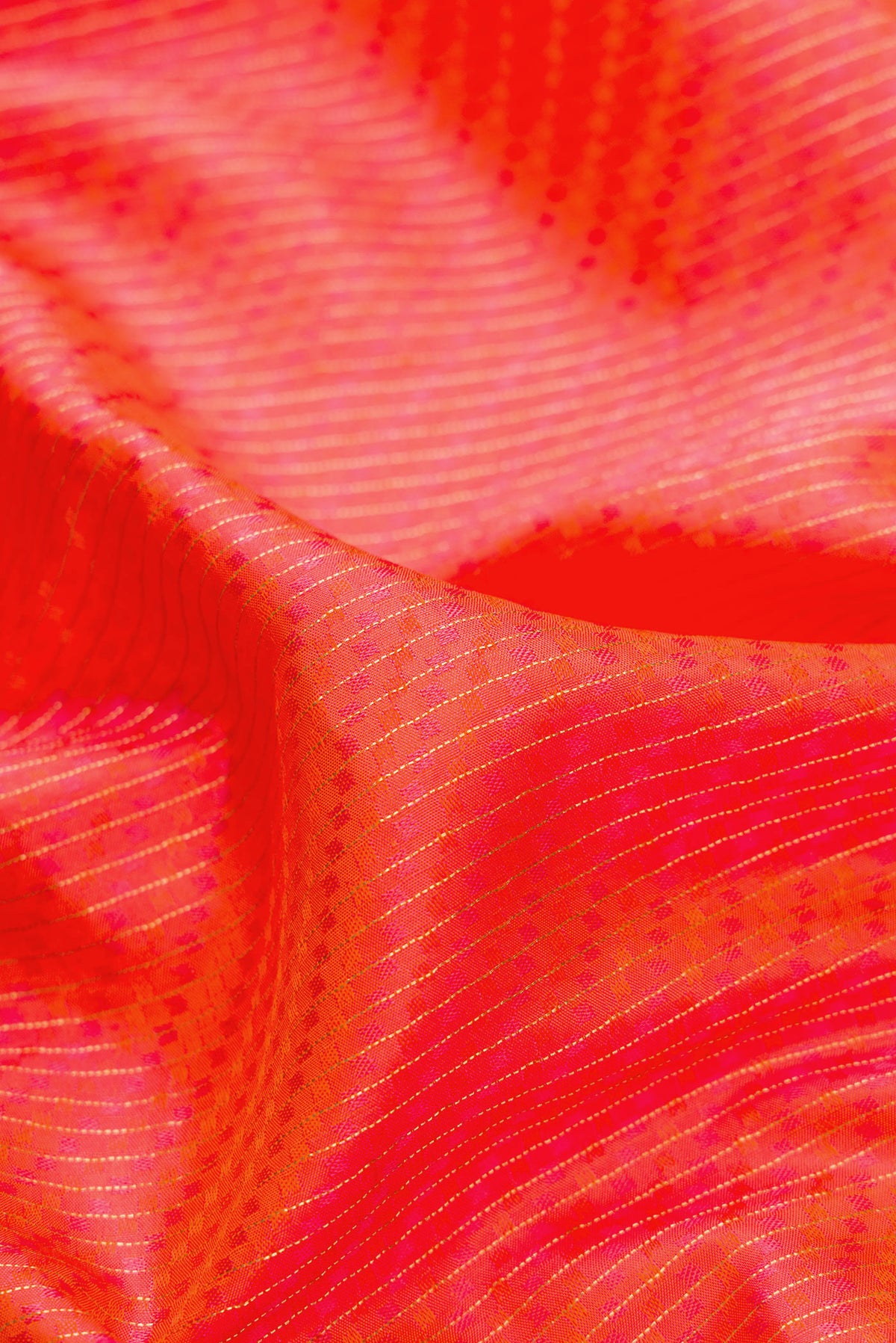 Close up of Orange Dual Tone Kanchipuram Silk Saree with Jacquard design on the body and Zari Border.  displaying folds