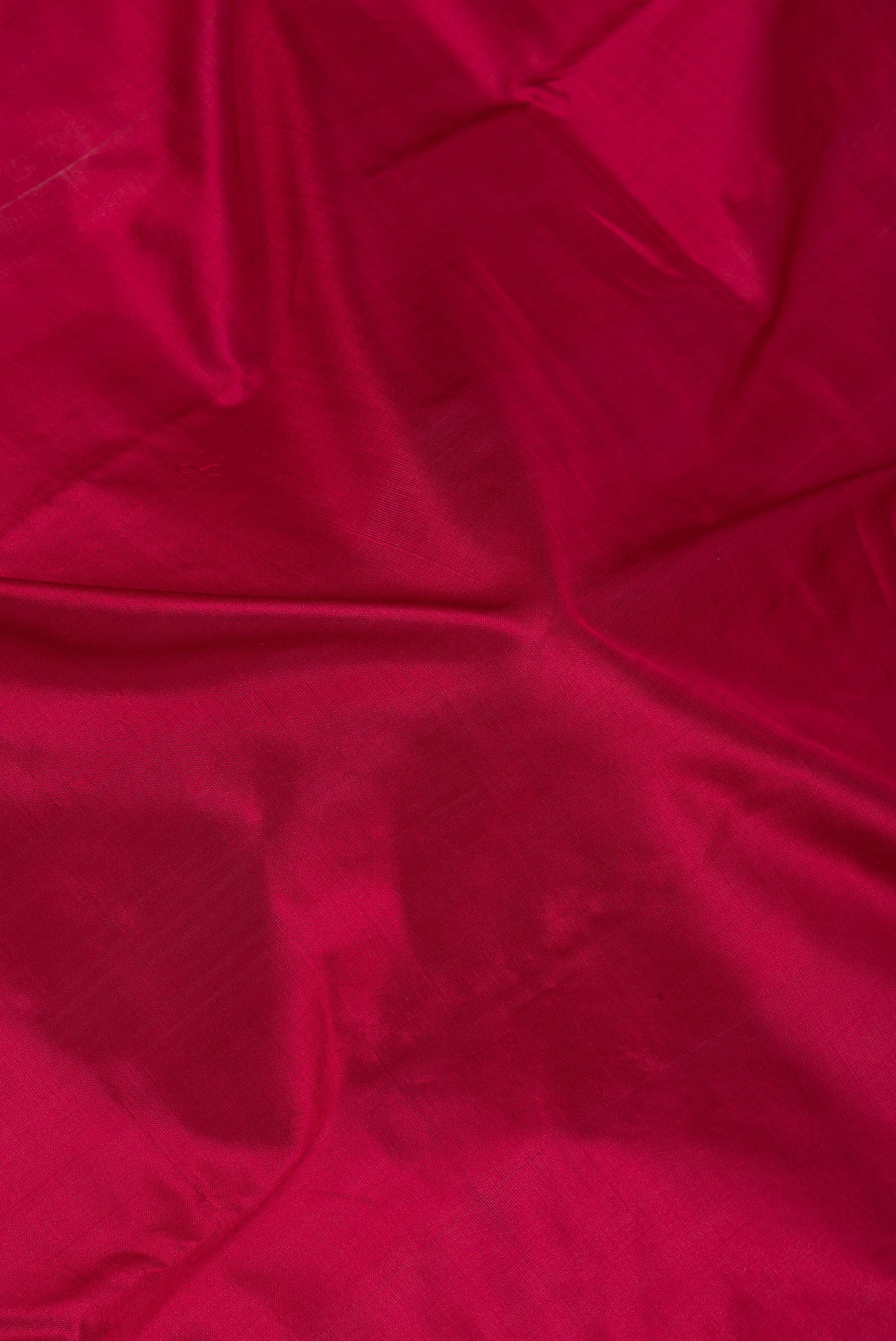 Close up of Maroon Kanjivaram Silk Saree with Plain Body and Zari Border.  displaying folds