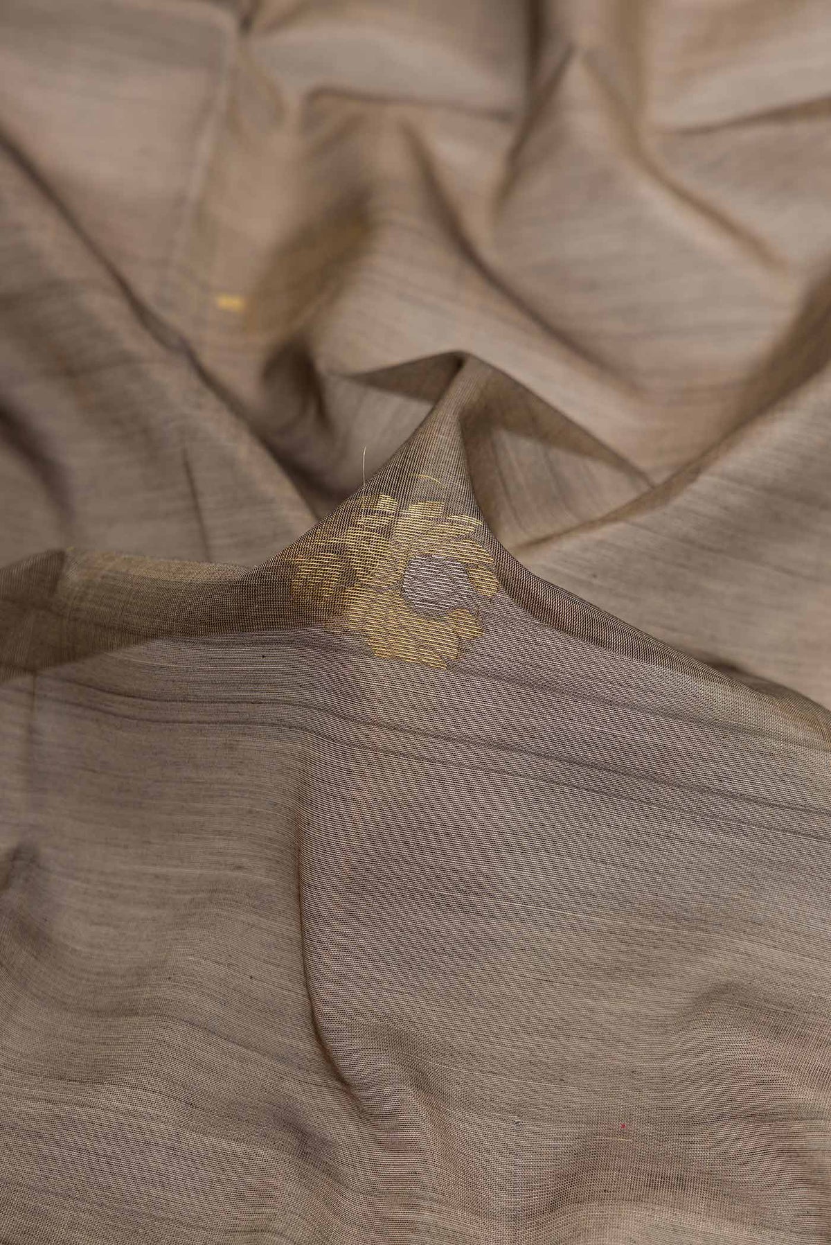 Close up of Grey Dual Tone Silk Cotton Saree with Zari Butta on the body and Zari Border displaying folds
