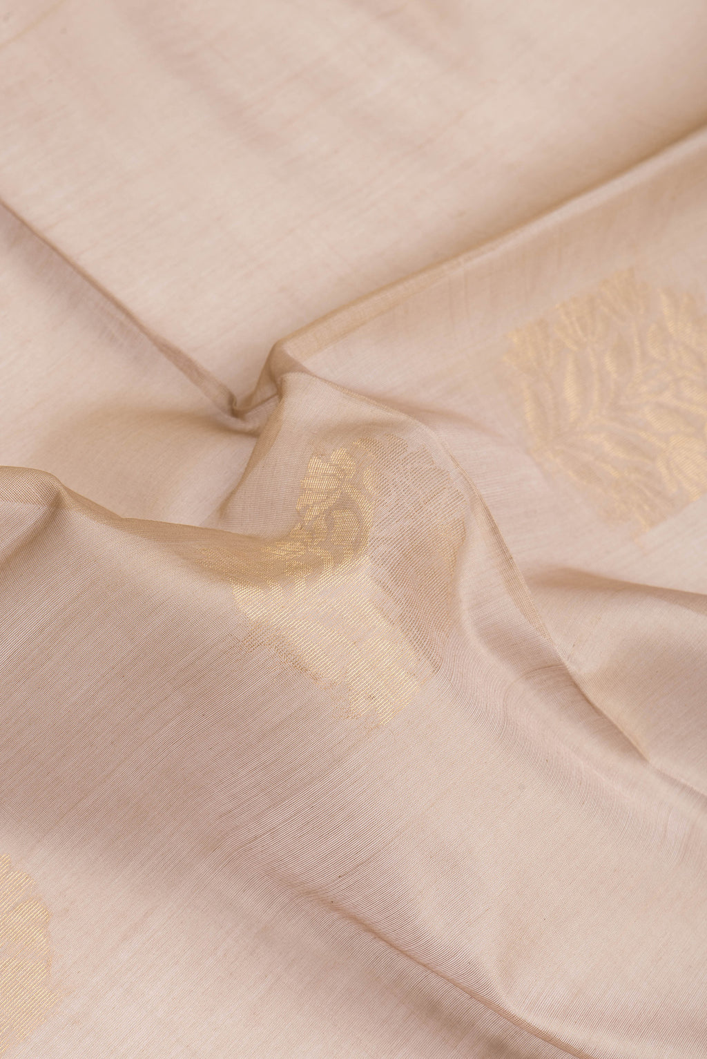 Close up of Dark Beige Silk Cotton Saree with Zari Butta on the body and Zari Border.  displaying folds