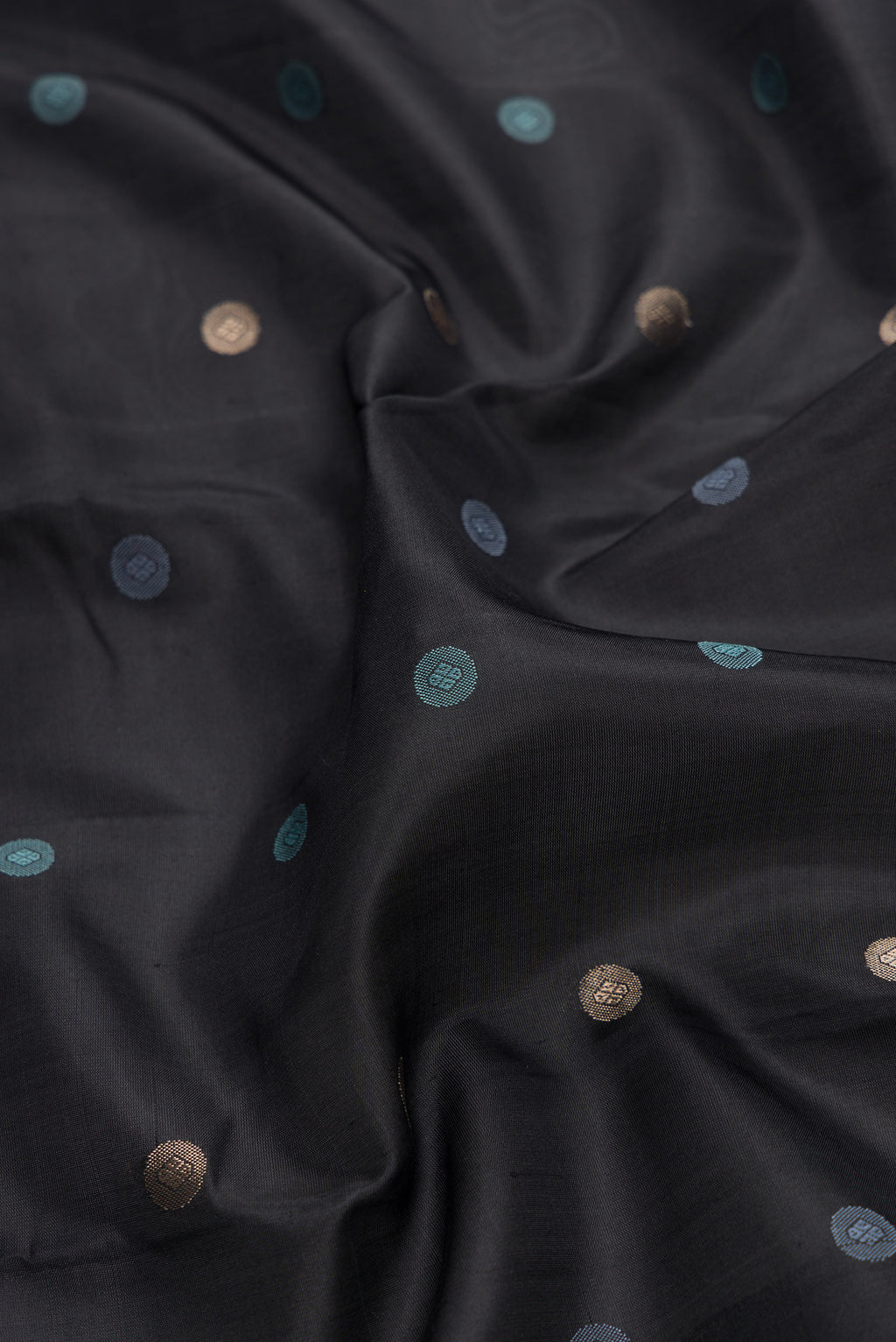 Close up of Black Dual Tone Kanchipuram Silk Saree with Zari And Thread Butta on the body and Zari And Thread Border.  displaying folds