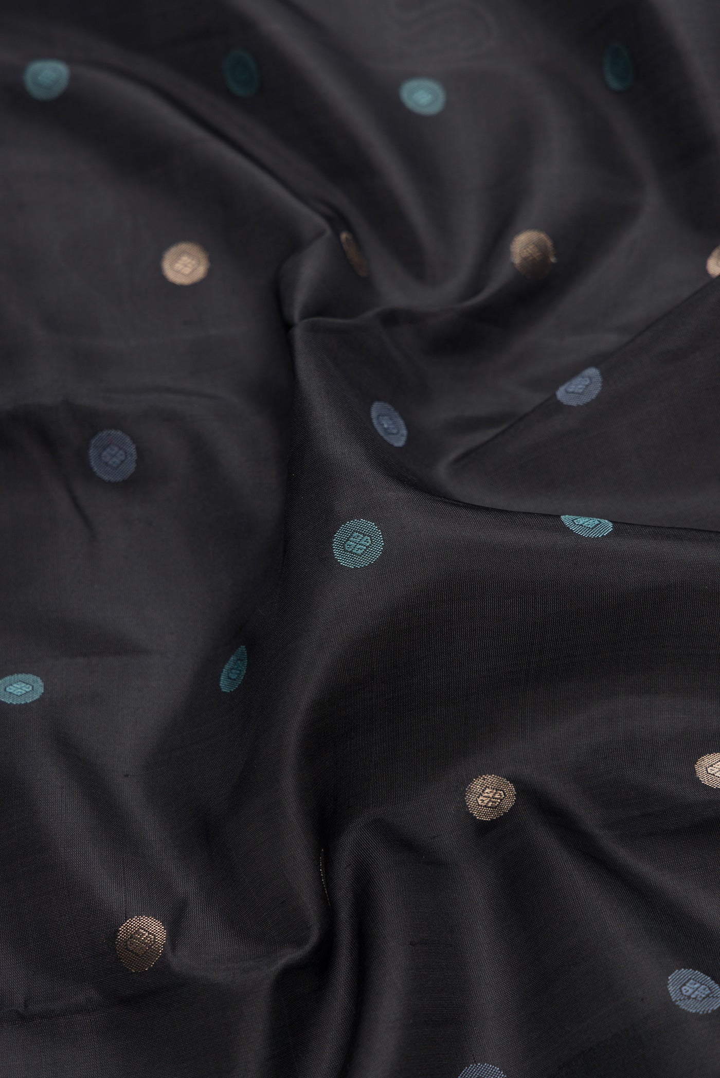 Close up of Black Dual Tone Kanchipuram Silk Saree with Zari And Thread Butta on the body and Zari And Thread Border.  displaying folds