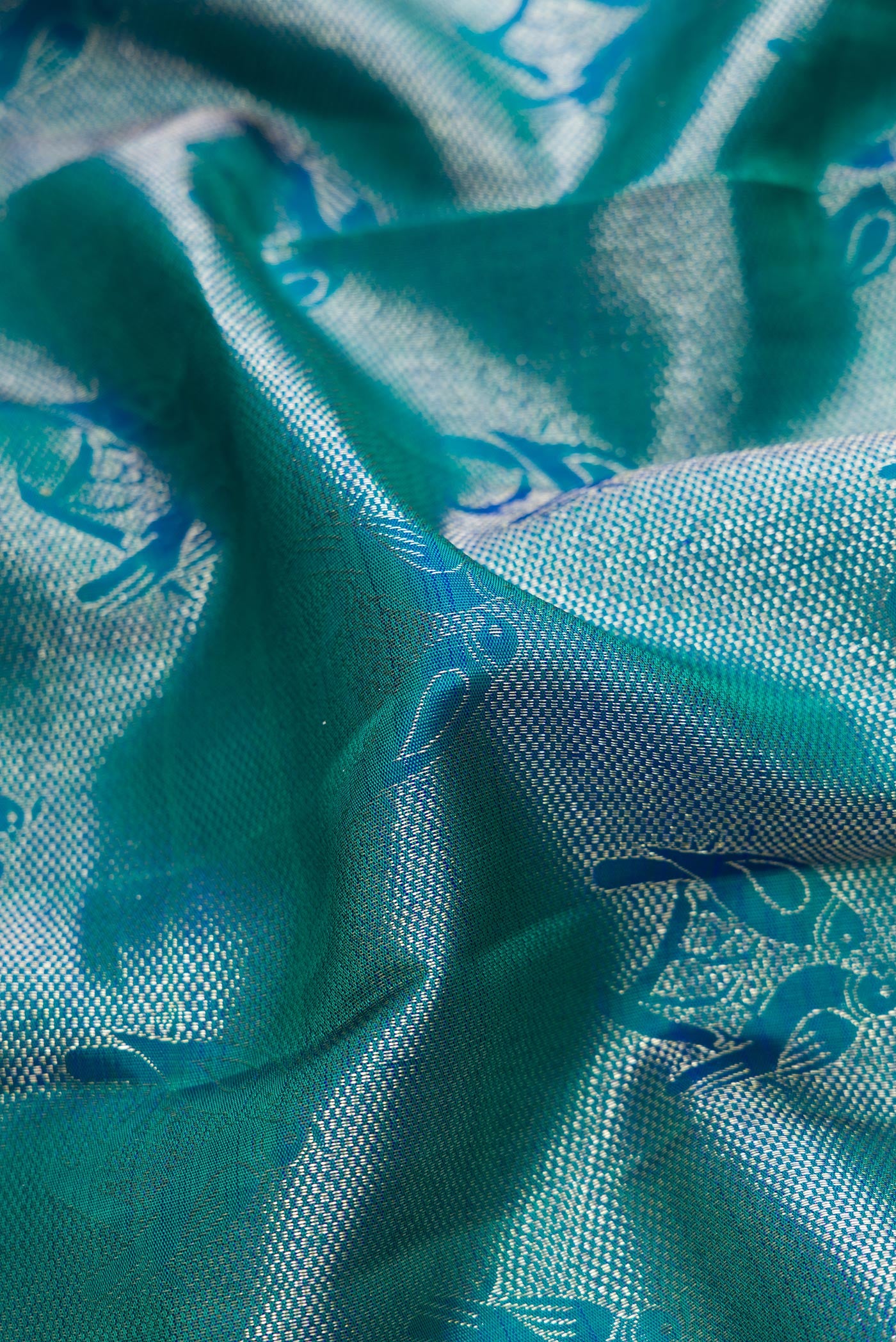 Close up of Peacock Blue Dual Tone Kanchipuram Silk Saree with Zari Brocade on the body and Zari Border.  displaying folds