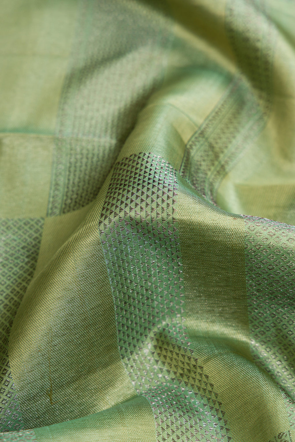 Close up of Mehandi Green Dual Tone Kanjivaram Silk Saree with Zari Brocade on the body and Zari Border.  displaying folds