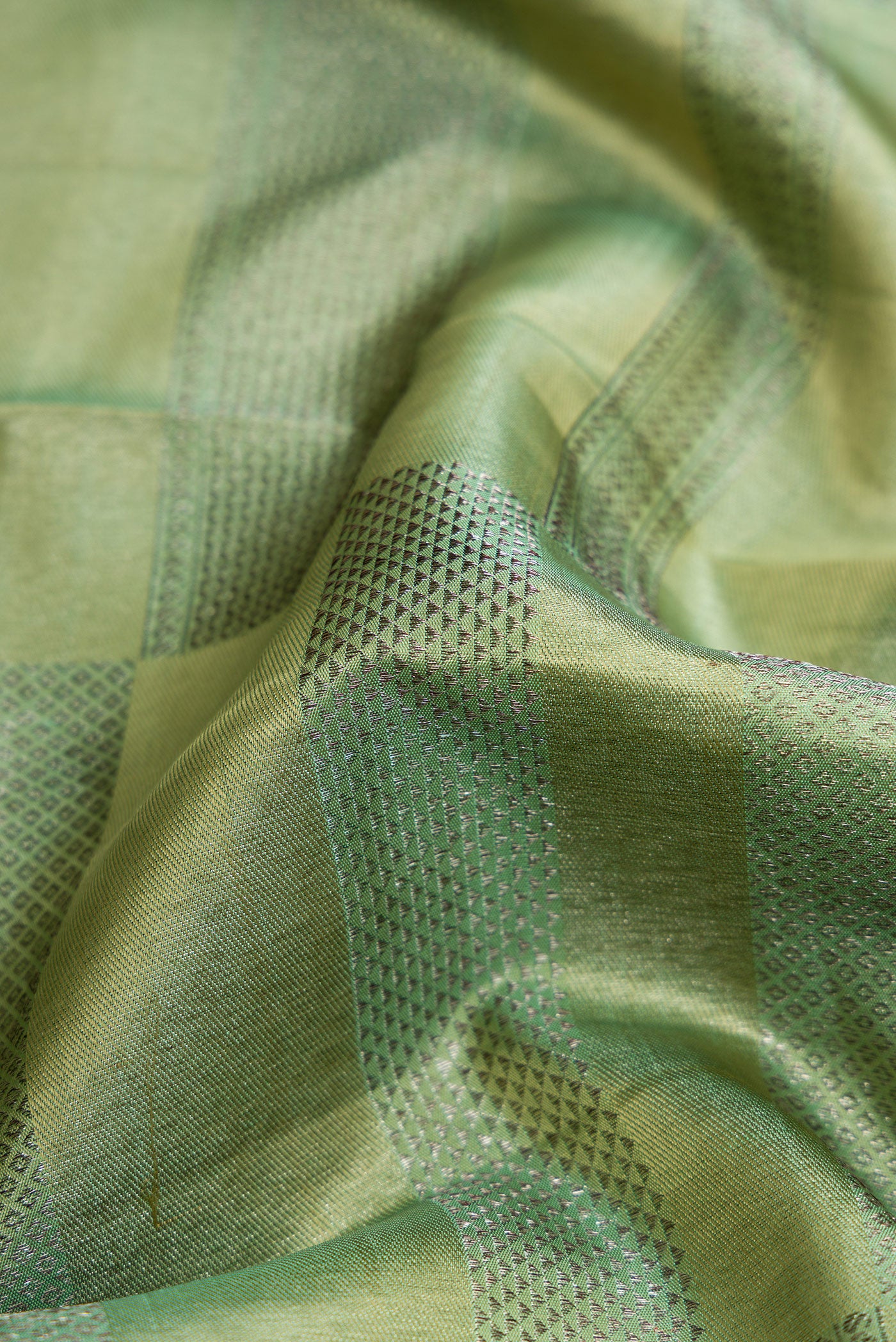 Close up of Mehandi Green Dual Tone Kanjivaram Silk Saree with Zari Brocade on the body and Zari Border.  displaying folds