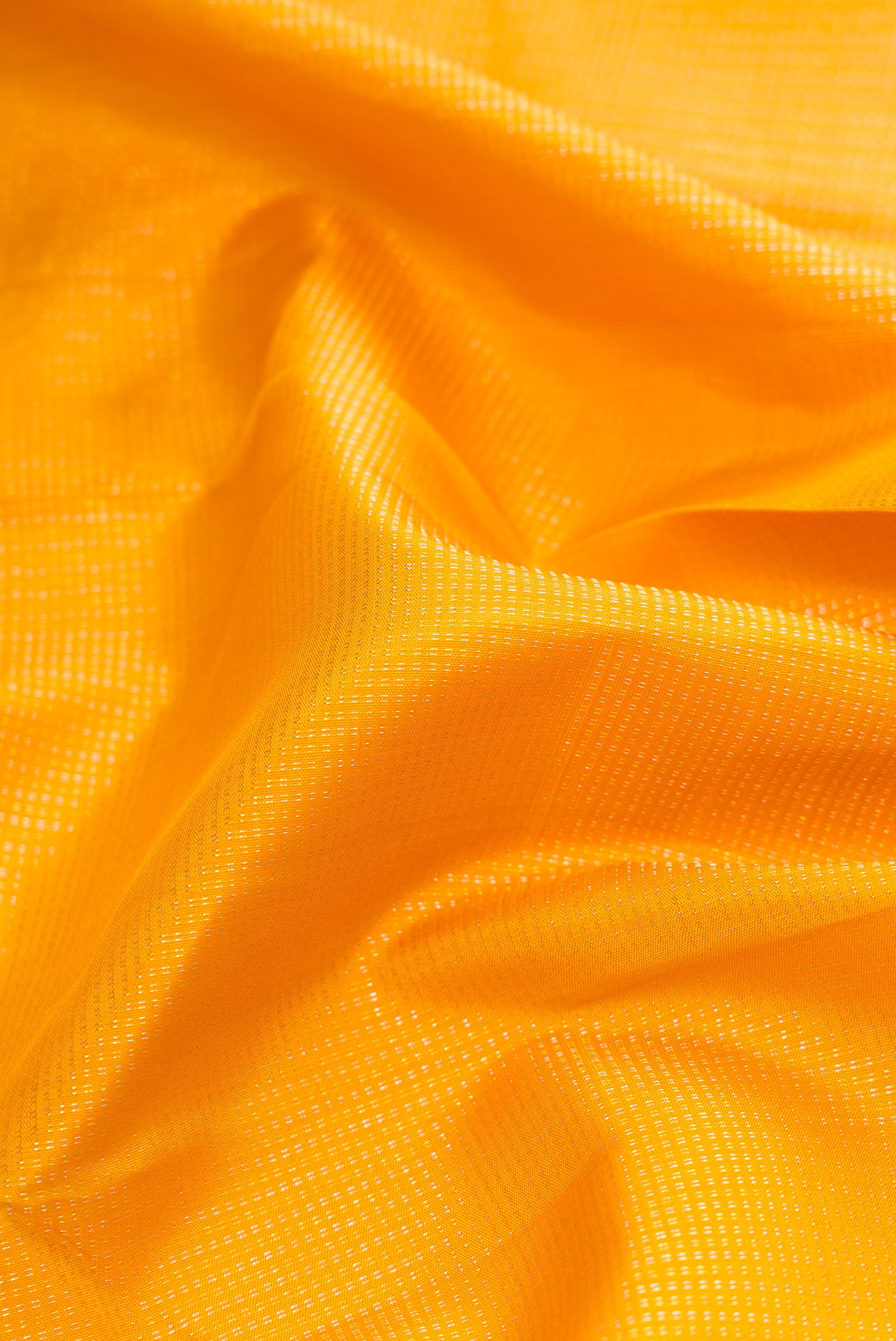Close up of Mustard Dual Tone Kanchipuram Silk Saree with Stripes on the body and Zari Border.  displaying folds