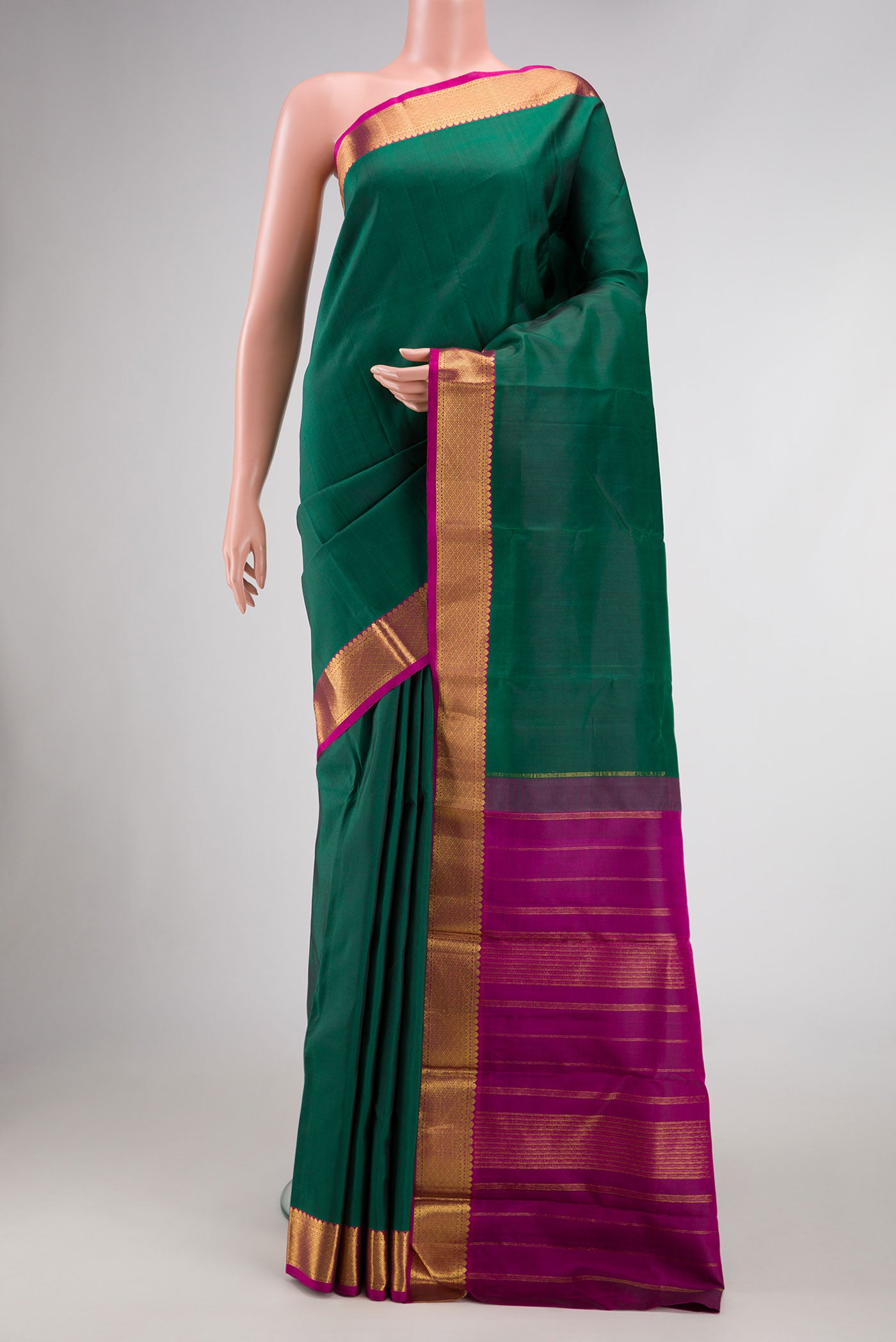 Bottle Green Dual Tone Kanchipuram Silk Saree with Plain Body and Zari Border.  displayed on a mannequin
