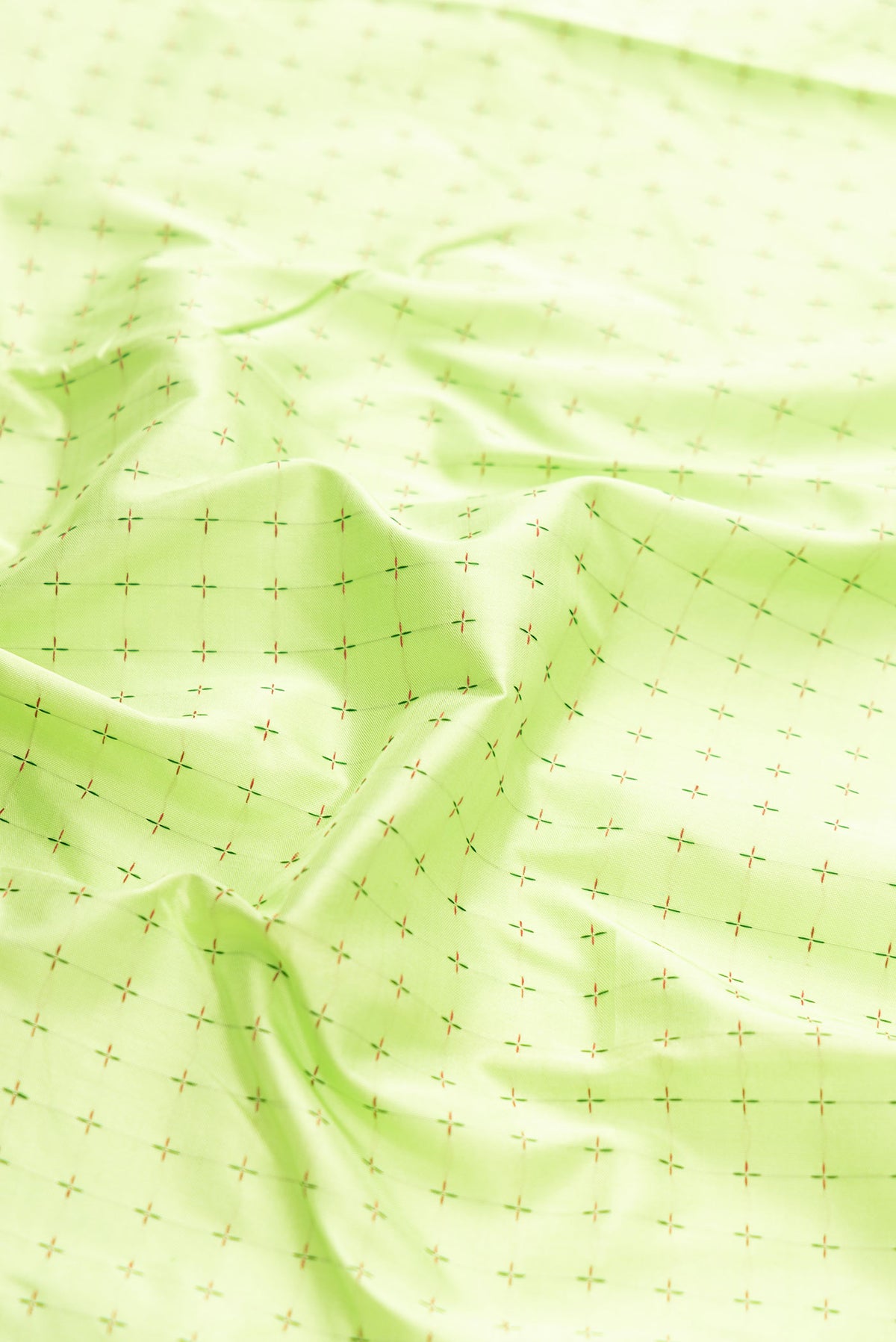 Close up of Pure Silk Pure Zari Parrot Green Dual Tone Kanchipuram Saree with Thread Butta on the body and Ganga Jamuna Border displaying folds