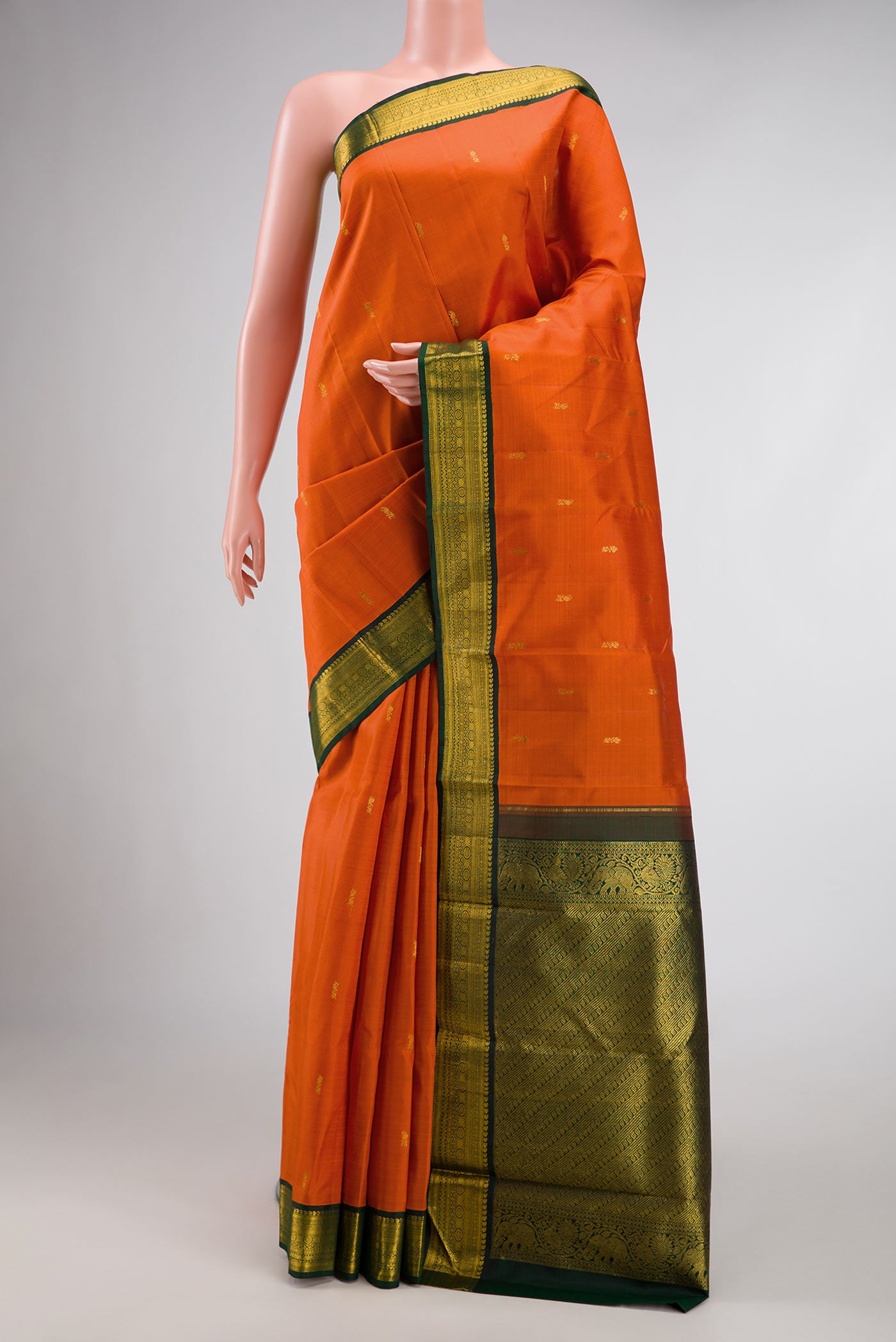 Orange Dual Tone Kanjivaram Silk Saree with Zari Butta on the body and Zari Border.  displayed on a mannequin