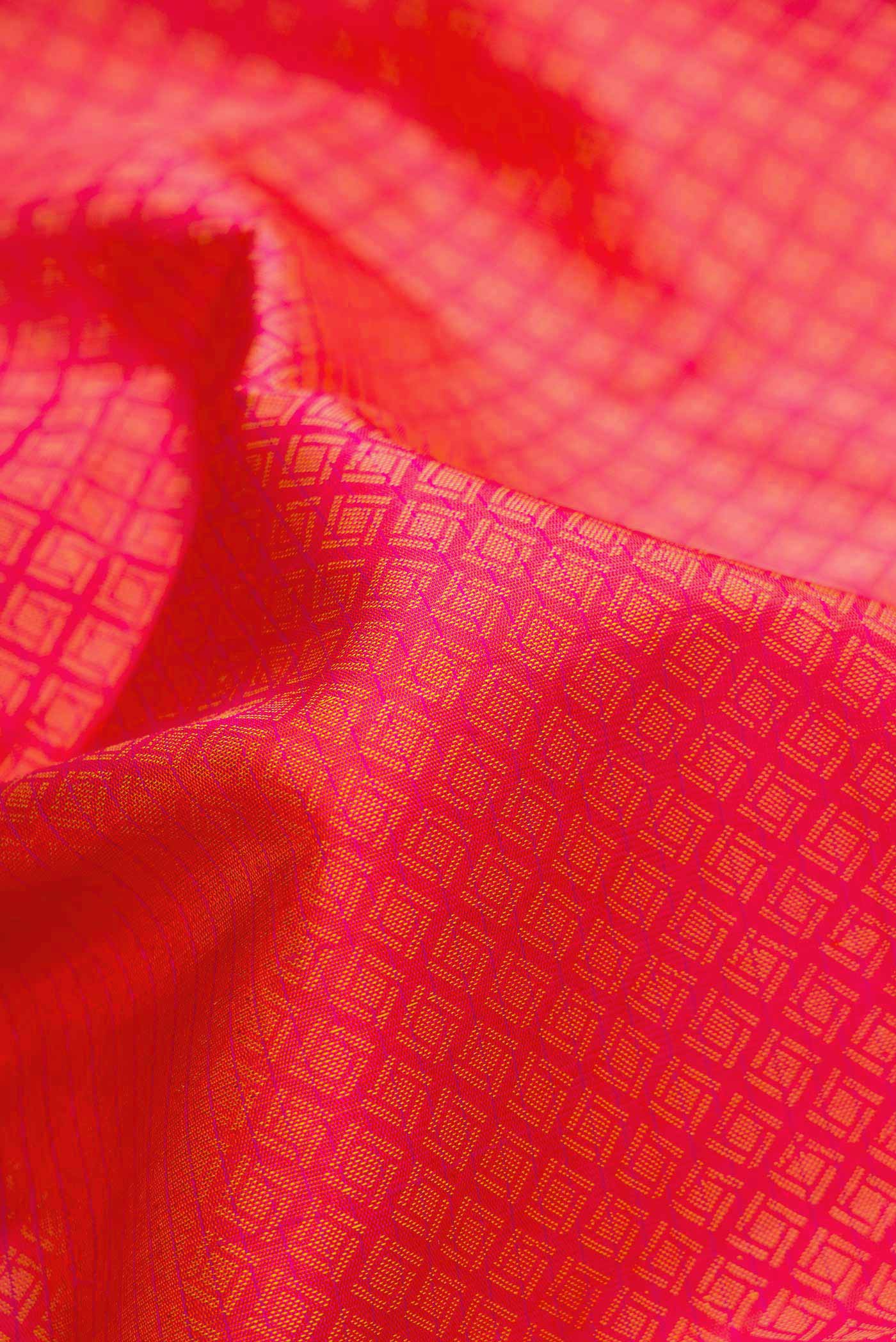 Close up of Orange Dual Tone Kanjivaram Silk Saree with Jacquard design on the body and Fancy Border.  displaying folds
