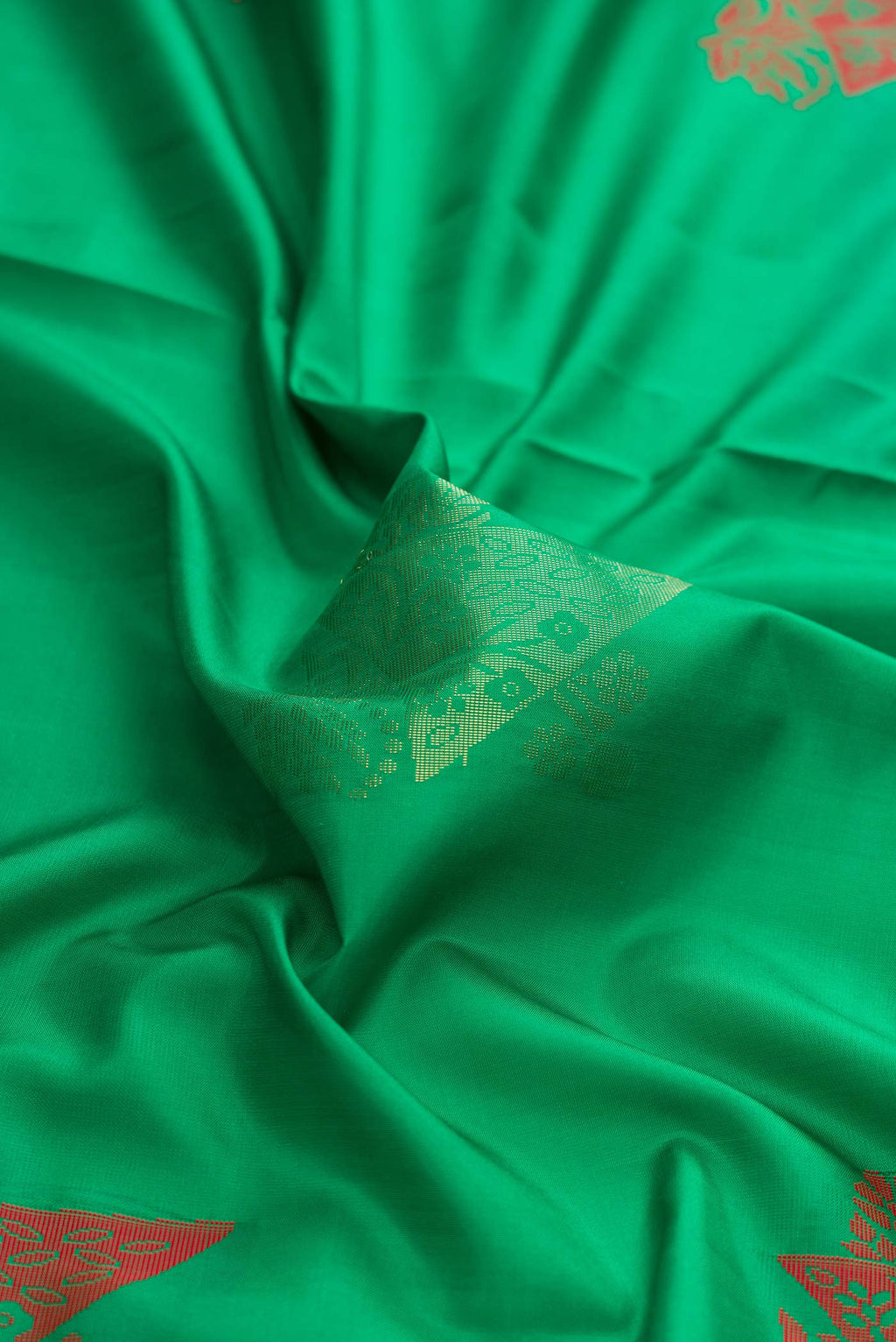 Close up of Green Dual Tone Soft Silk Saree with Zari And Thread Butta on the body and Zari Border displaying folds