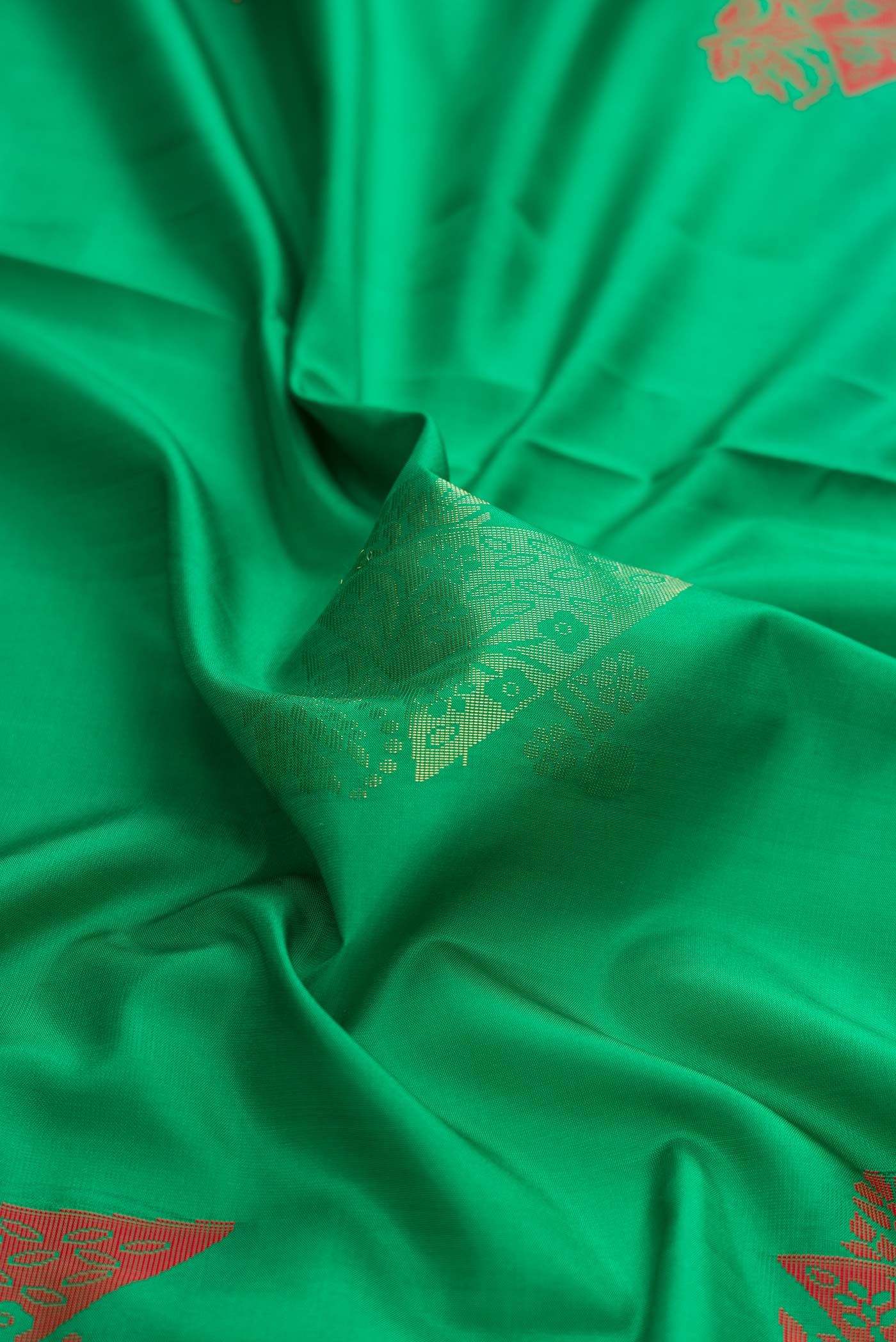 Close up of Green Dual Tone Soft Silk Saree with Zari And Thread Butta on the body and Zari Border displaying folds