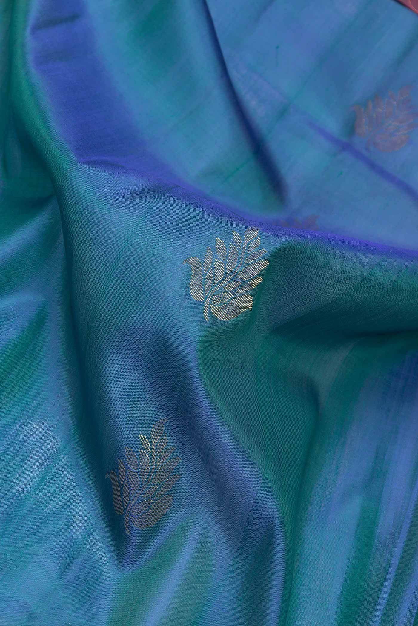 Close up of Peacock Blue Dual Tone Soft Silk Saree with Zari Butta on the body and Zari Border.  displaying folds