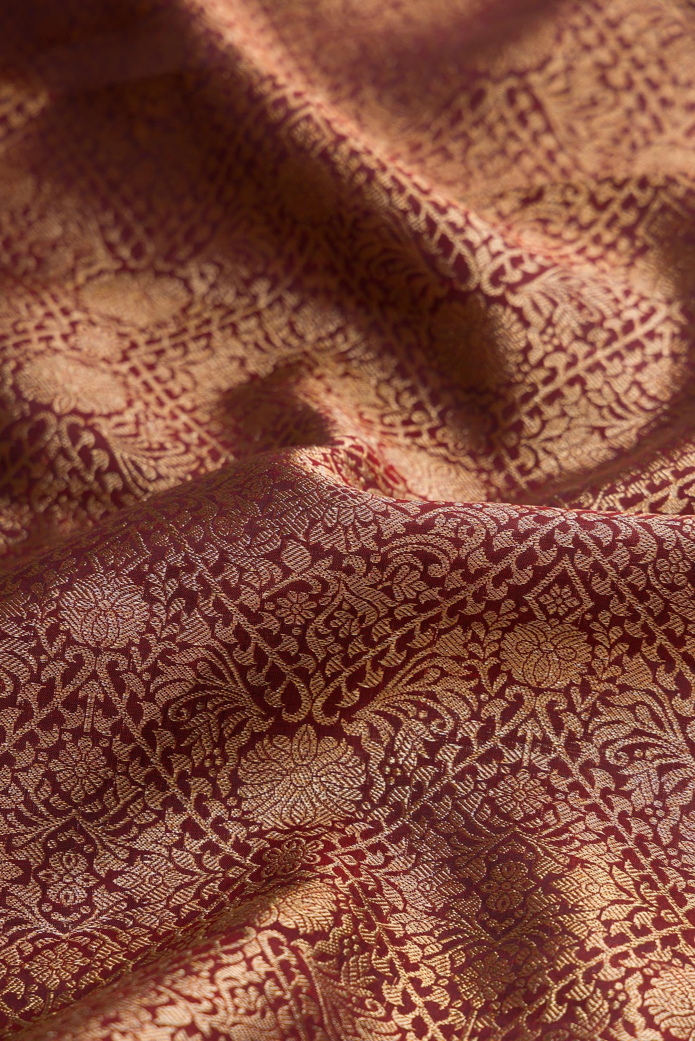 Close up of Maroon Dual Tone Kanchipuram Silk Saree with Zari Brocade on the body and Zari Border.  displaying folds