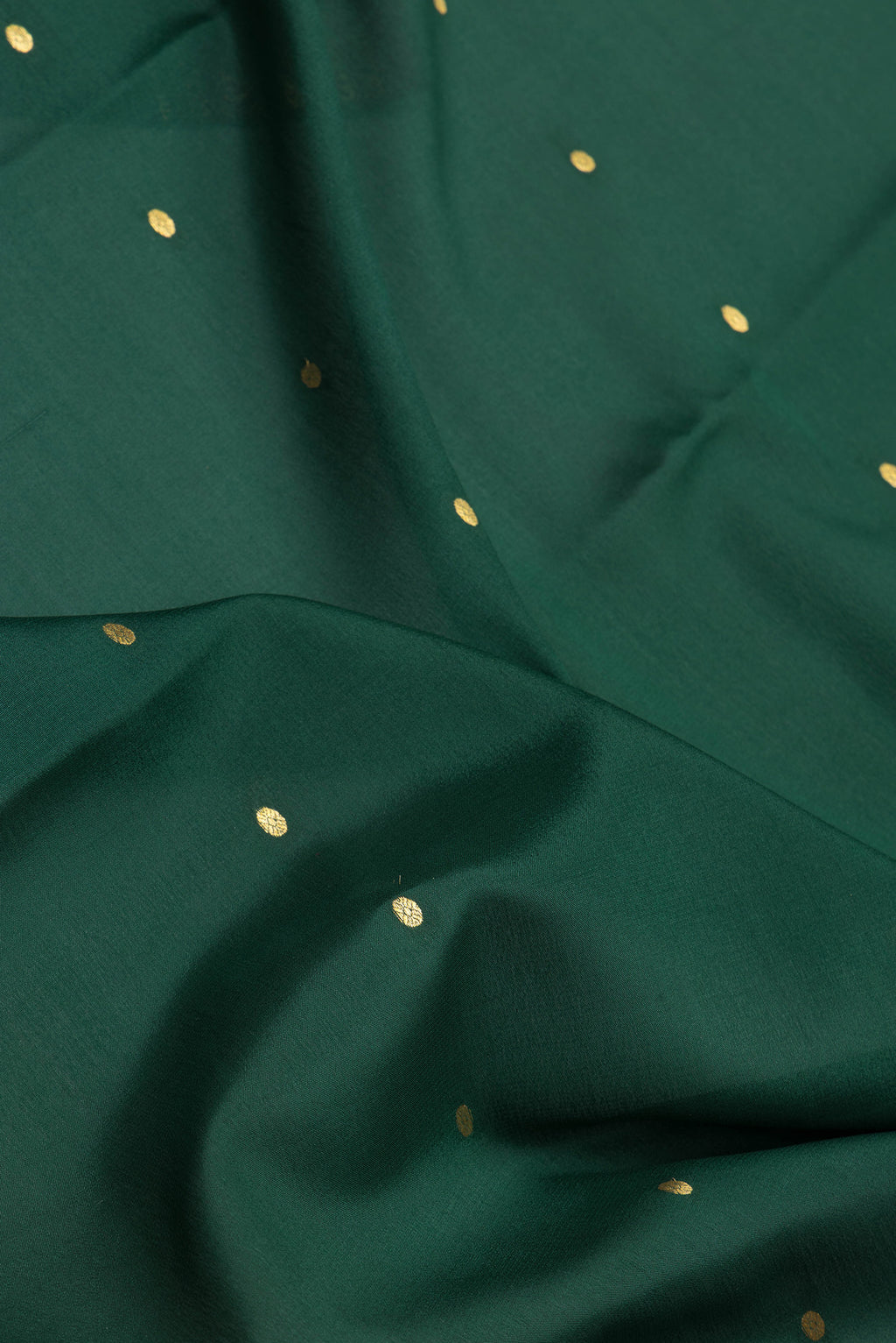 Close up of Bottle Green Mysore Silk Saree with Zari Butta on the body and Zari Border.  displaying folds