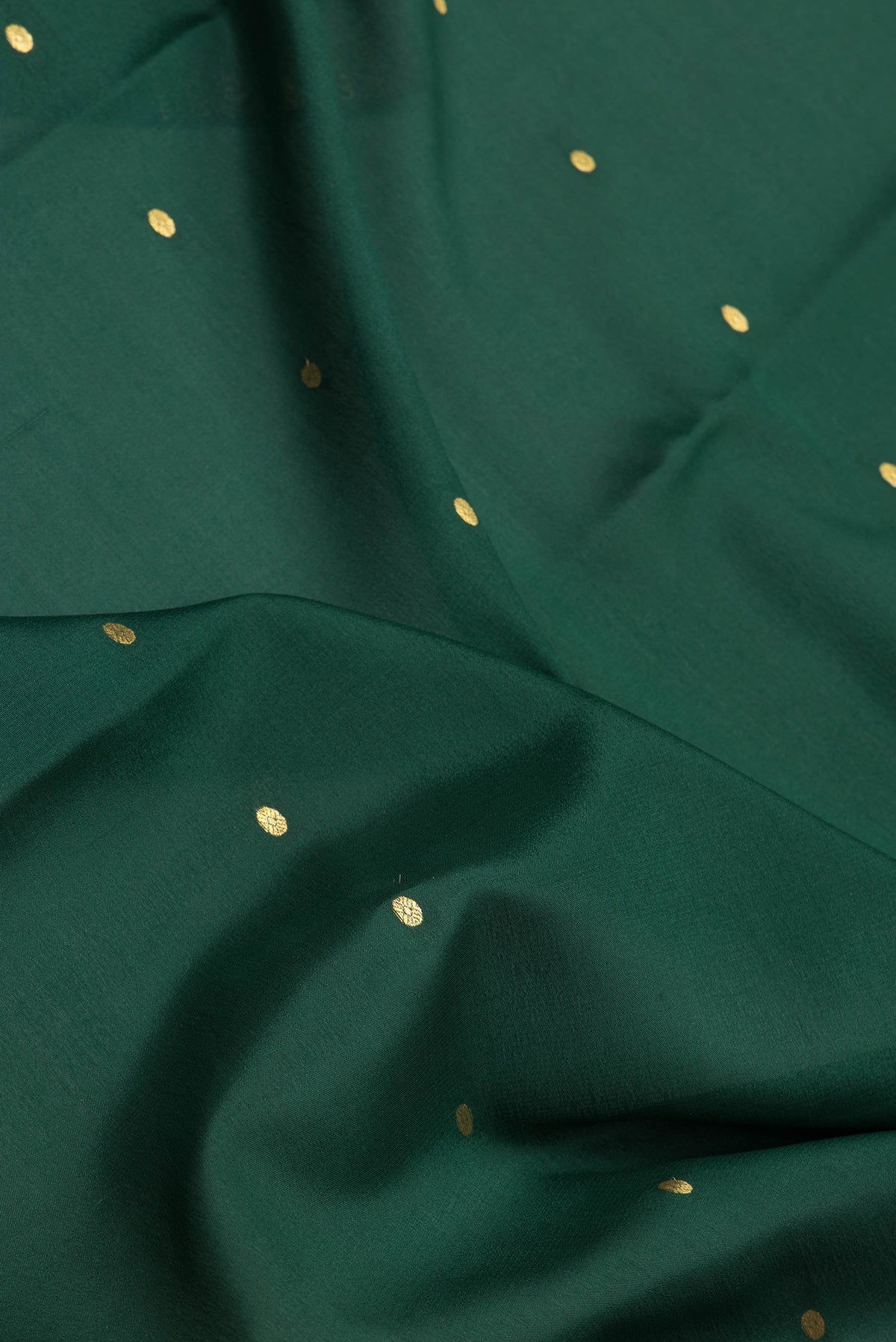 Close up of Bottle Green Mysore Silk Saree with Zari Butta on the body and Zari Border.  displaying folds