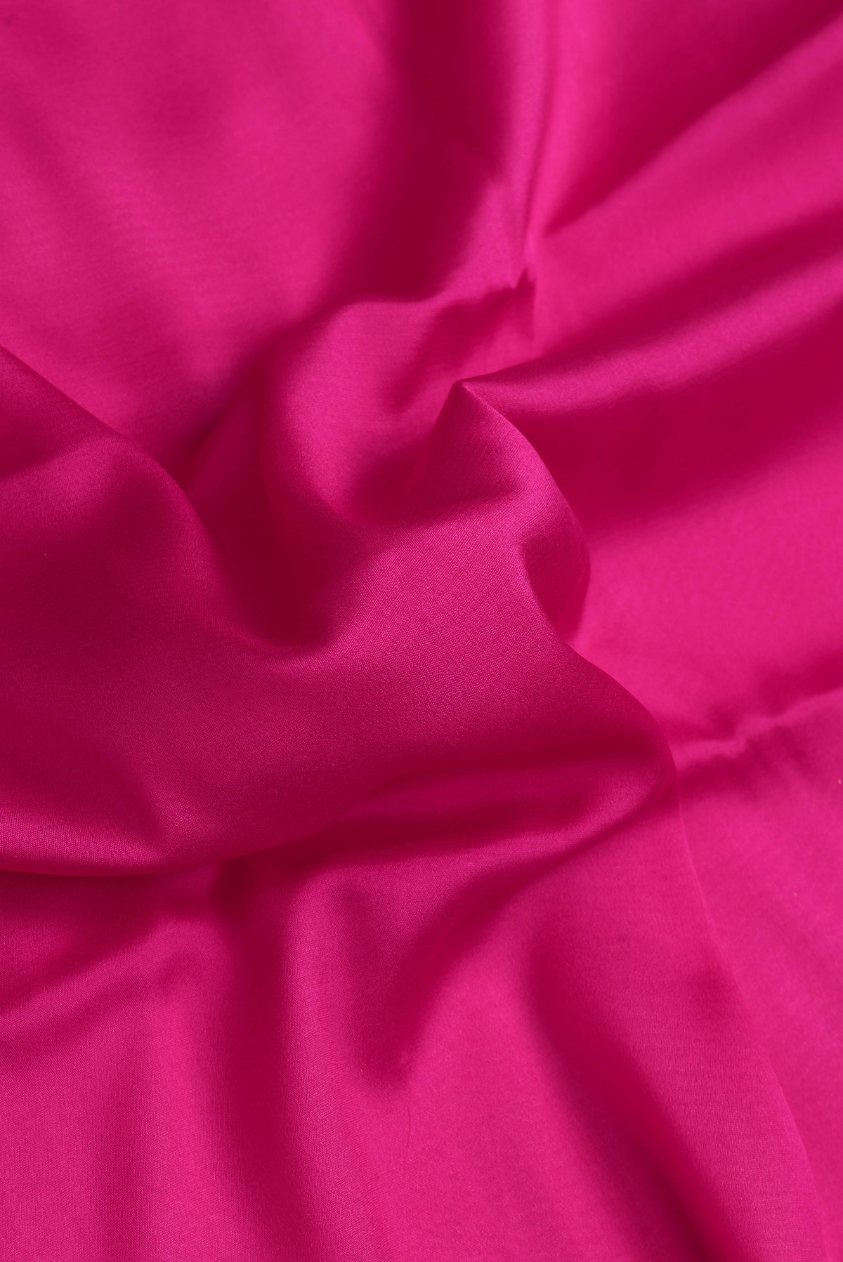 Close up of Dark Pink Dual Tone Mysore Crepe Saree with Plain Body and Zari Border.  displaying folds