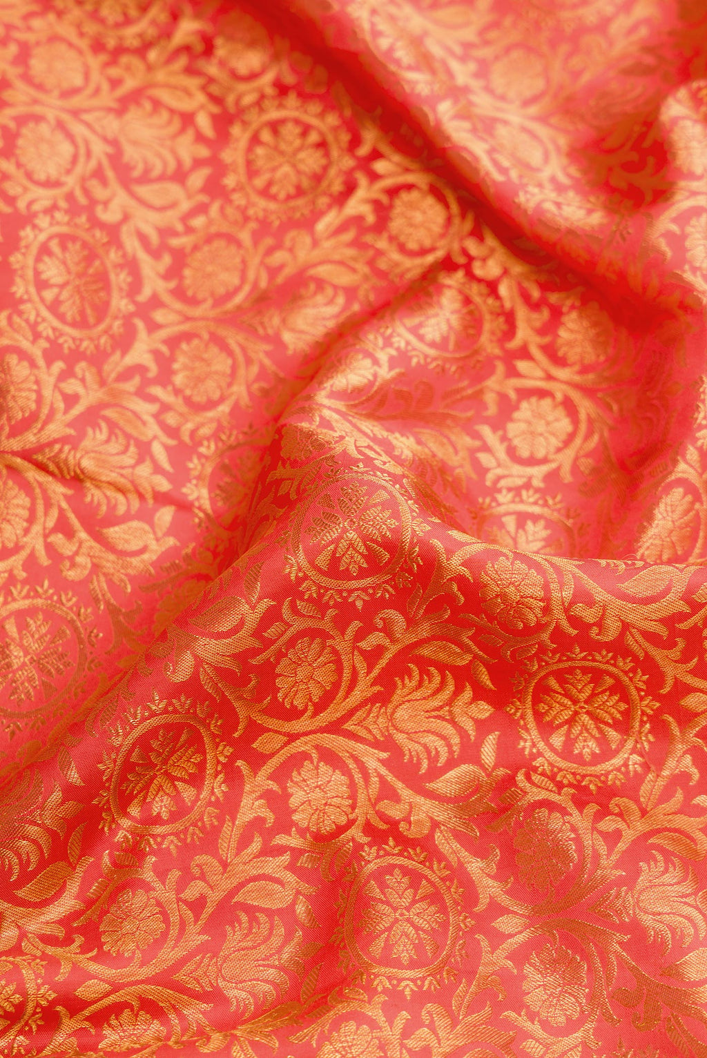 Close up of Coral Dual Tone Kanjivaram Silk Saree with Zari Brocade on the body and Zari Border.  displaying folds