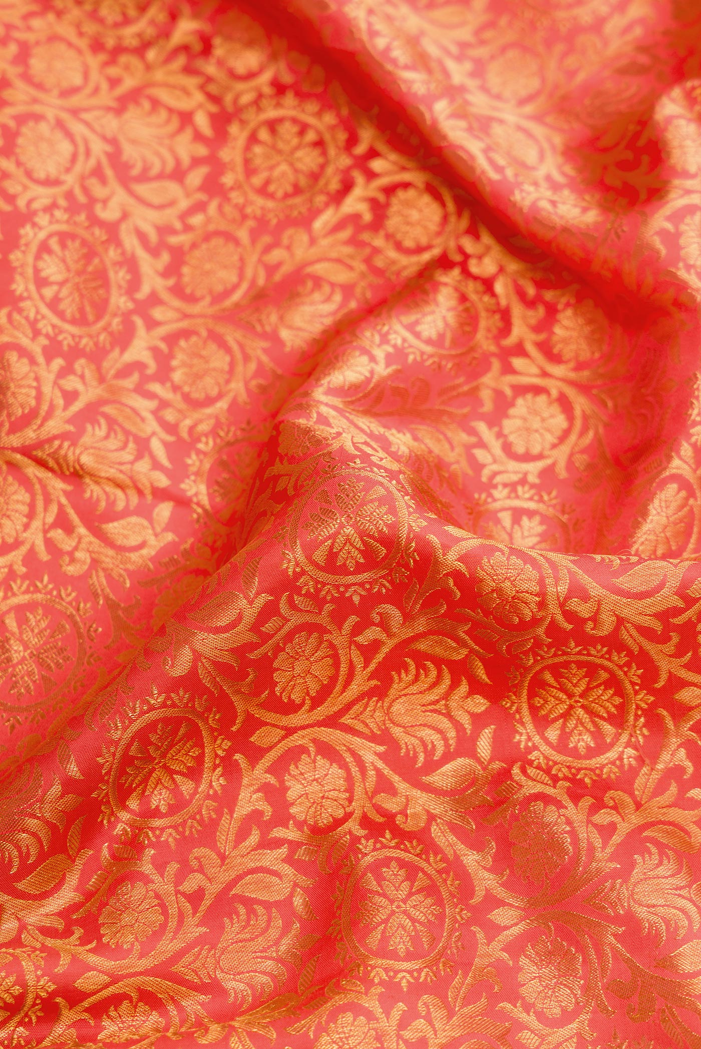 Close up of Coral Dual Tone Kanjivaram Silk Saree with Zari Brocade on the body and Zari Border.  displaying folds