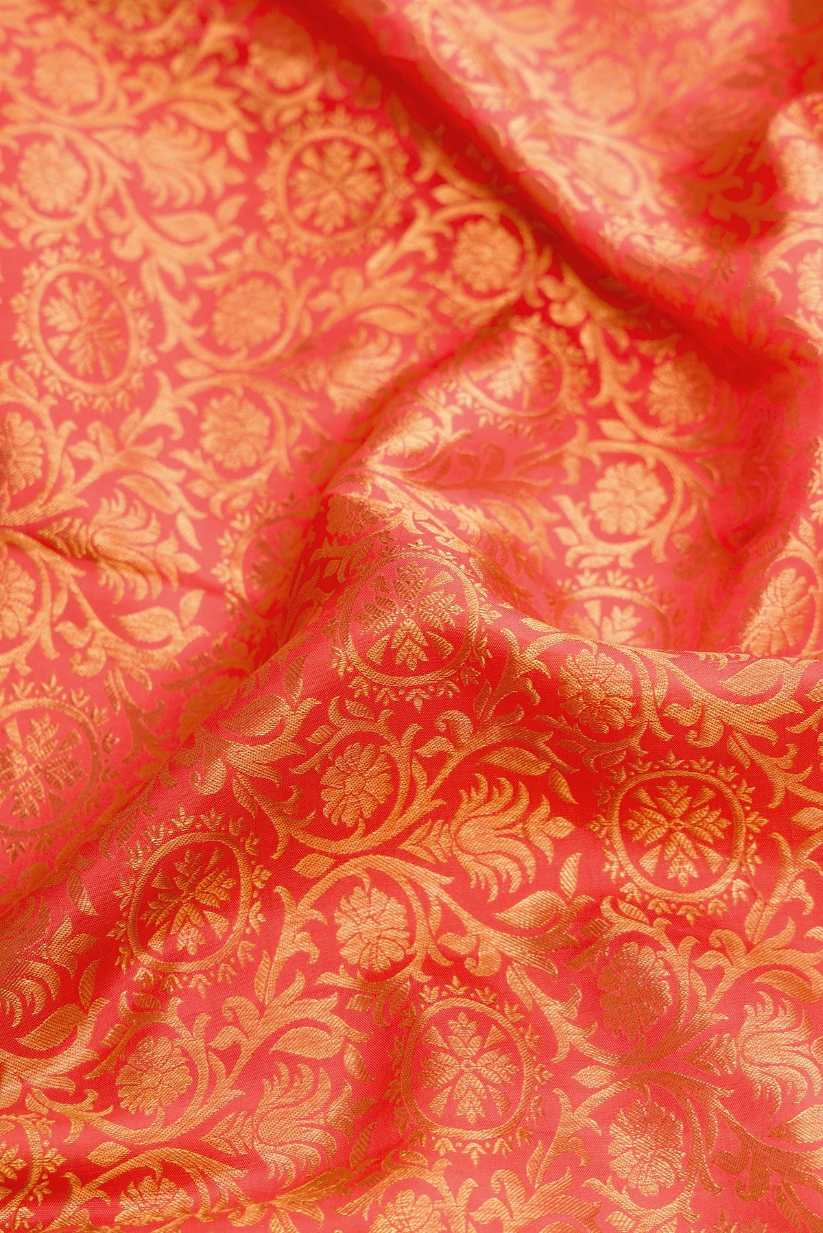 Close up of Coral Dual Tone Kanjivaram Silk Saree with Zari Brocade on the body and Zari Border.  displaying folds