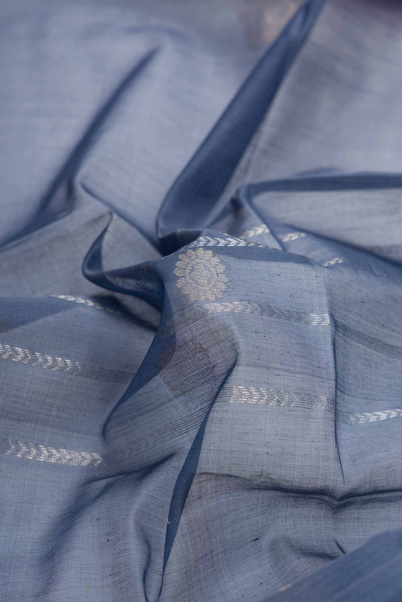 Close up of Grey Dual Tone Silk Cotton Saree with Zari Butta on the body and Zari Border displaying folds
