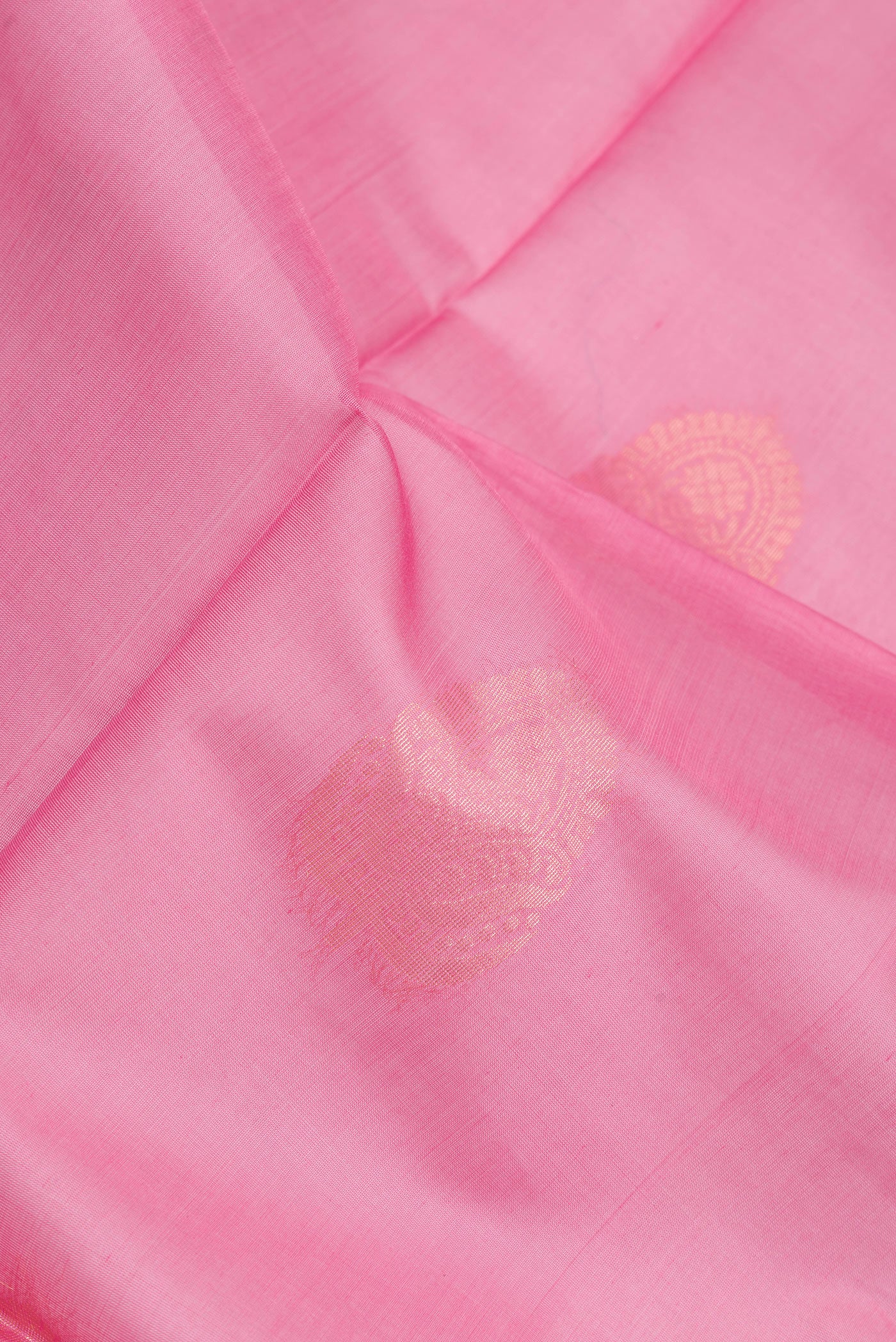 Close up of Pink Silk Cotton Saree with Zari Butta on the body and Zari Border.  displaying folds