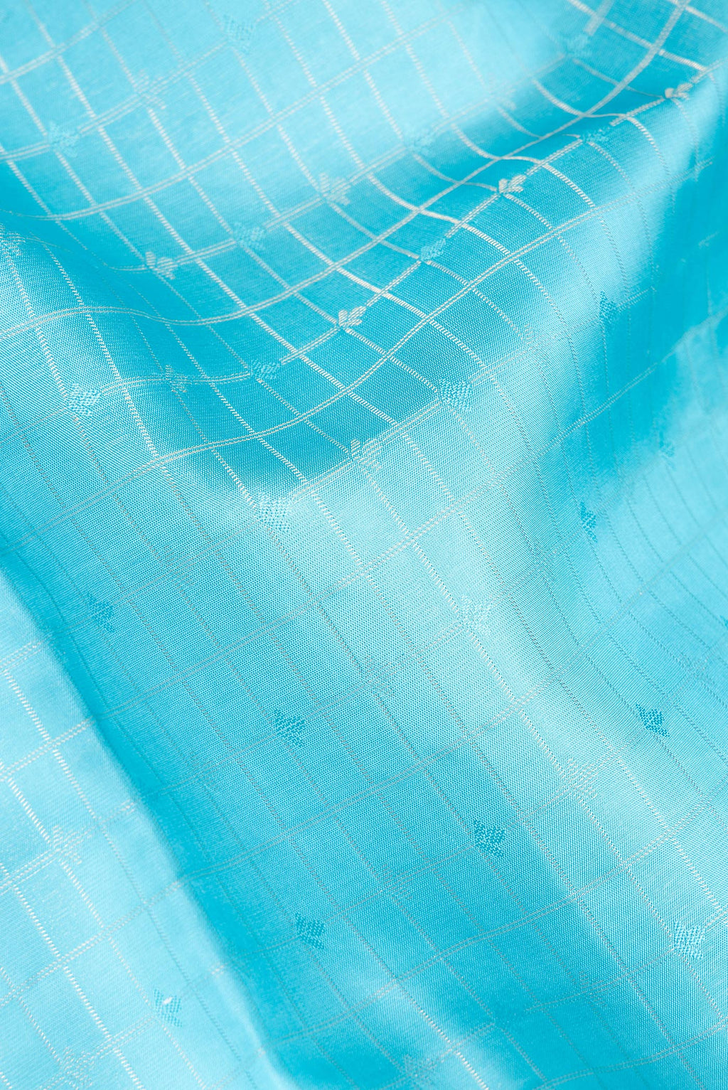 Close up of Pure Silk Sky Blue Soft Saree with Checked design on the body and Zari Border.  displaying folds