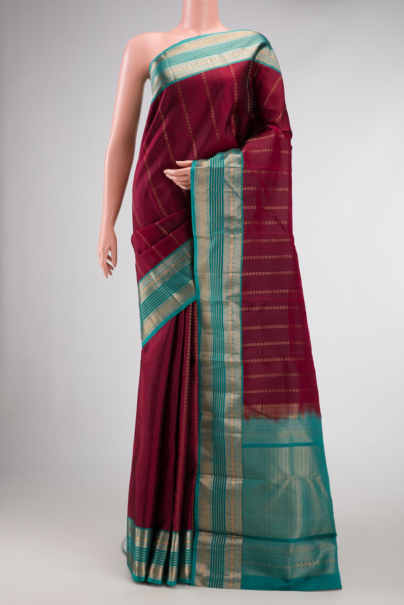Maroon Dual Tone Kanjivaram Silk Saree with Stripes on the body and Zari Border.  displayed on a mannequin