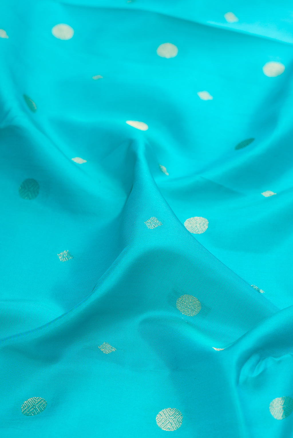 Close up of Turquoise Kanchipuram Silk Saree with Zari Butta on the body and Zari Border.  displaying folds