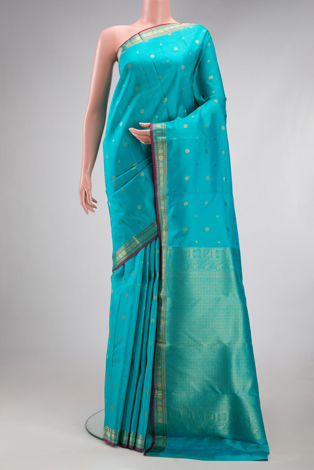 Turquoise Kanchipuram Silk Saree with Zari Butta on the body and Zari Border.  displayed on a mannequin