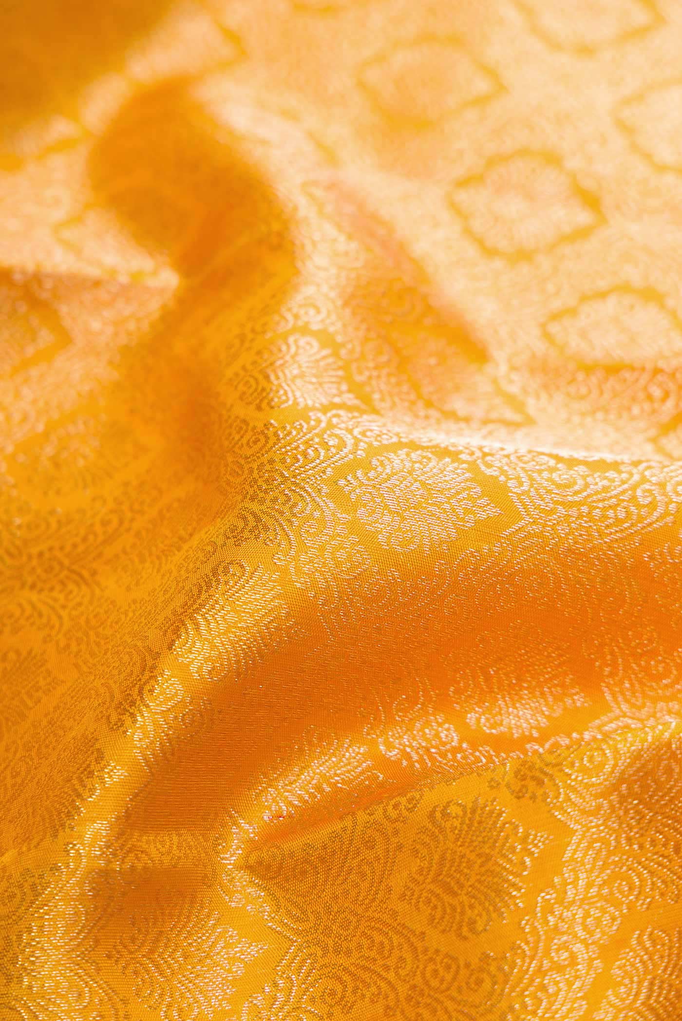 Close up of Yellow Kanchipuram Silk Saree with Zari Brocade on the body and Zari Border displaying folds