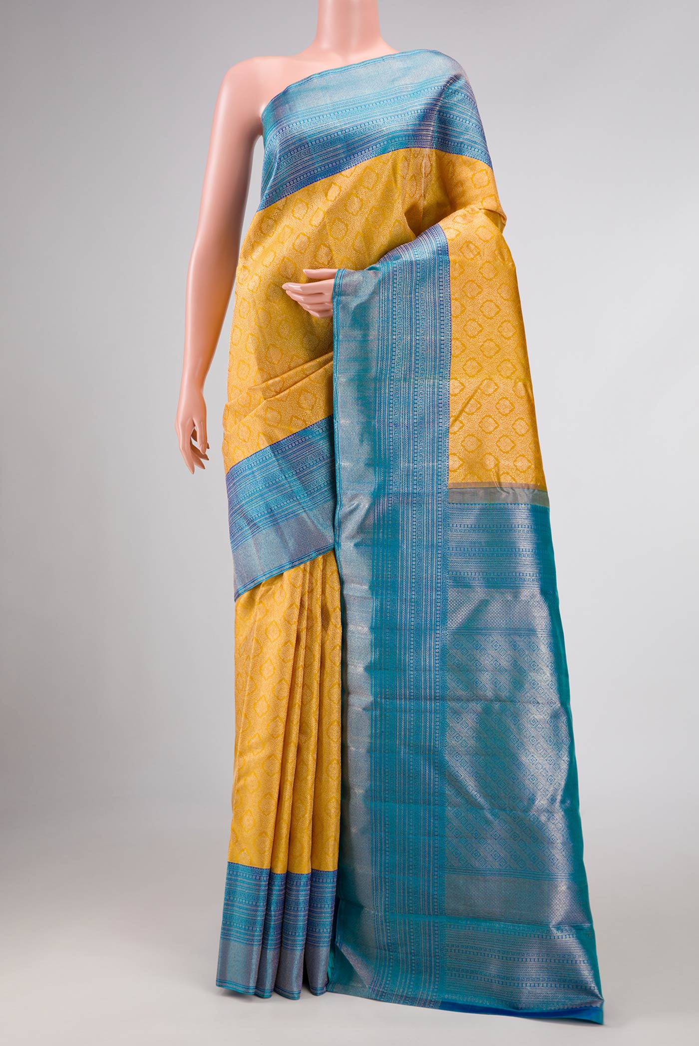 Yellow Kanchipuram Silk Saree with Zari Brocade on the body and Zari Border displayed on a mannequin