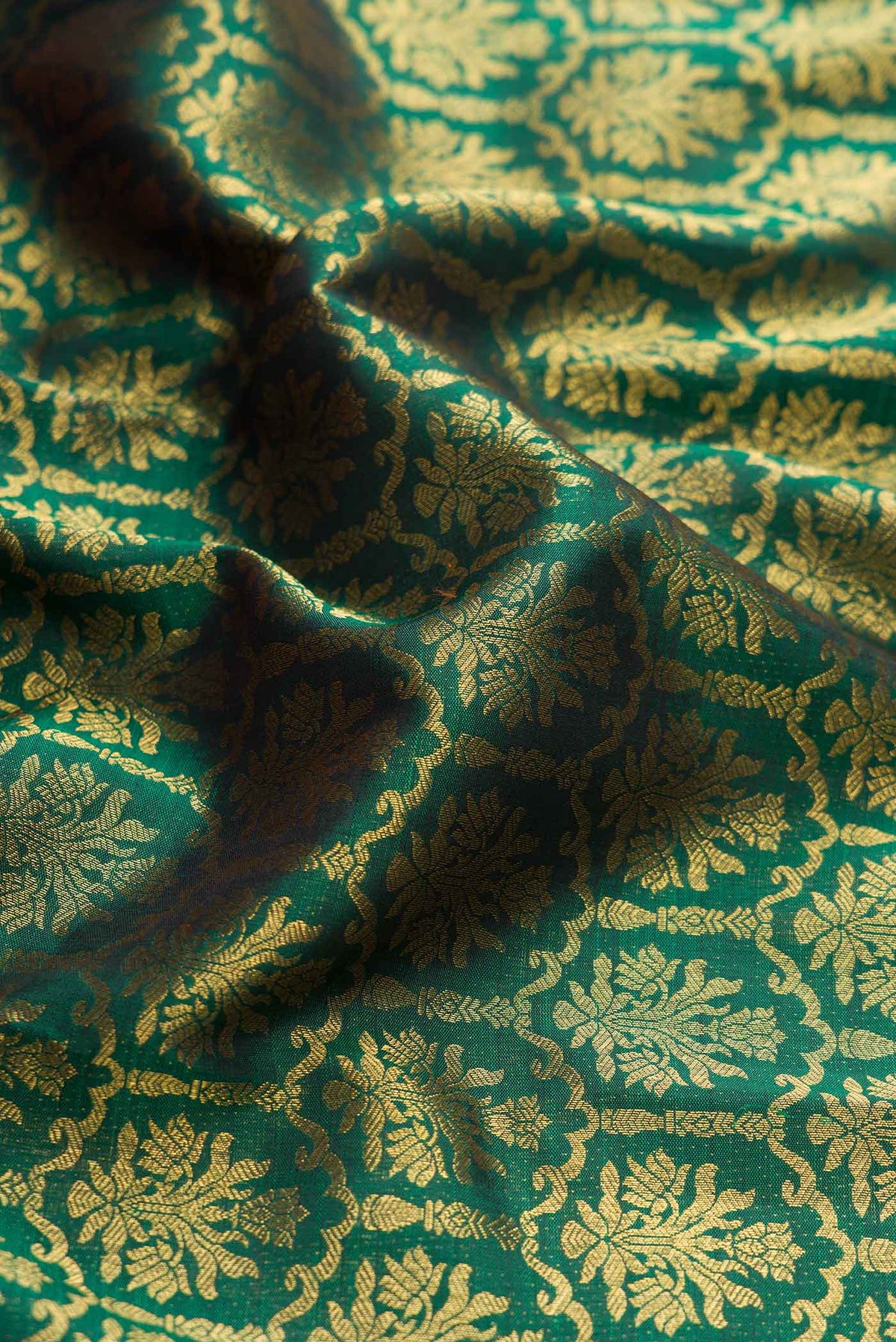 Close up of Pure Silk Pure Zari Green Dual Tone Kanchipuram Saree with Zari Brocade on the body and Zari Border displaying folds