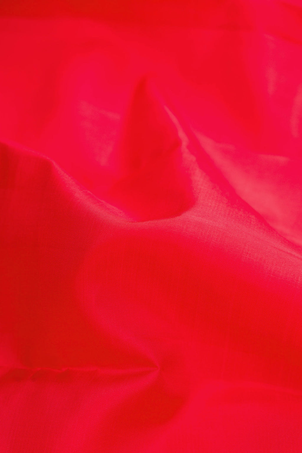 Close up of Red Dual Tone Kanchipuram Silk Saree with Plain Body and Temple Border.  displaying folds