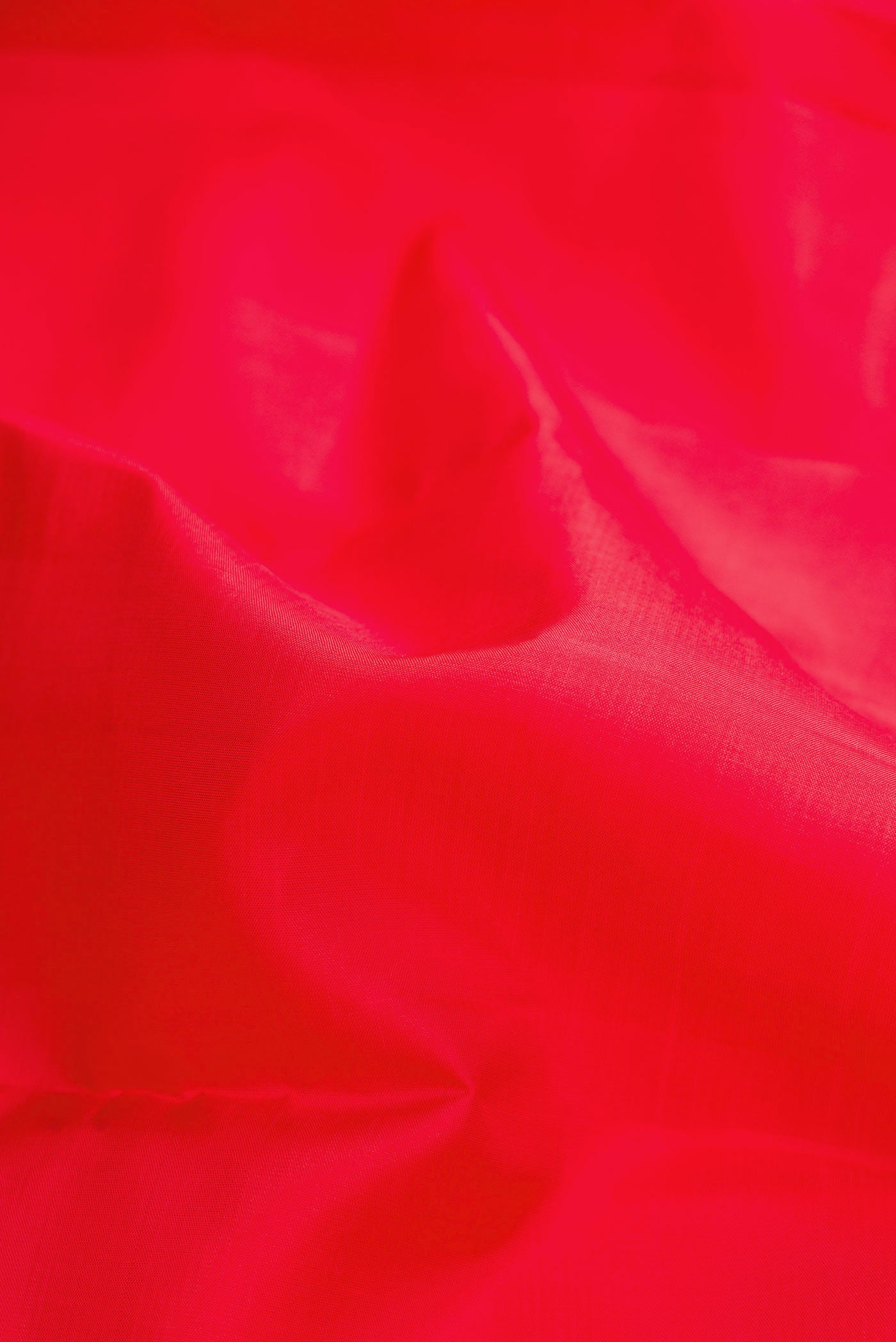 Close up of Red Dual Tone Kanchipuram Silk Saree with Plain Body and Temple Border.  displaying folds