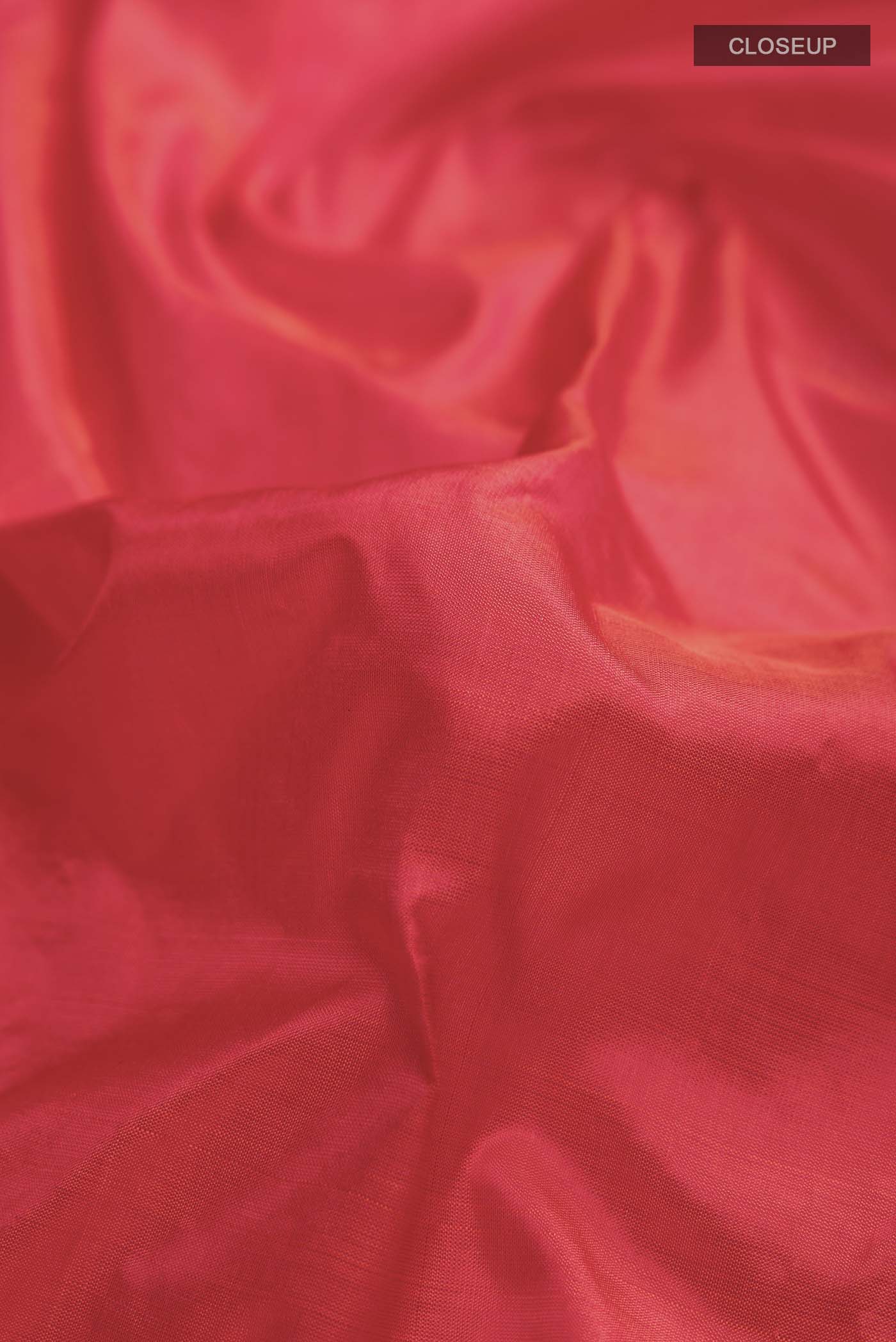 Close up of Orange Kanchipuram Silk Saree with Plain Body and Thread Border displaying folds