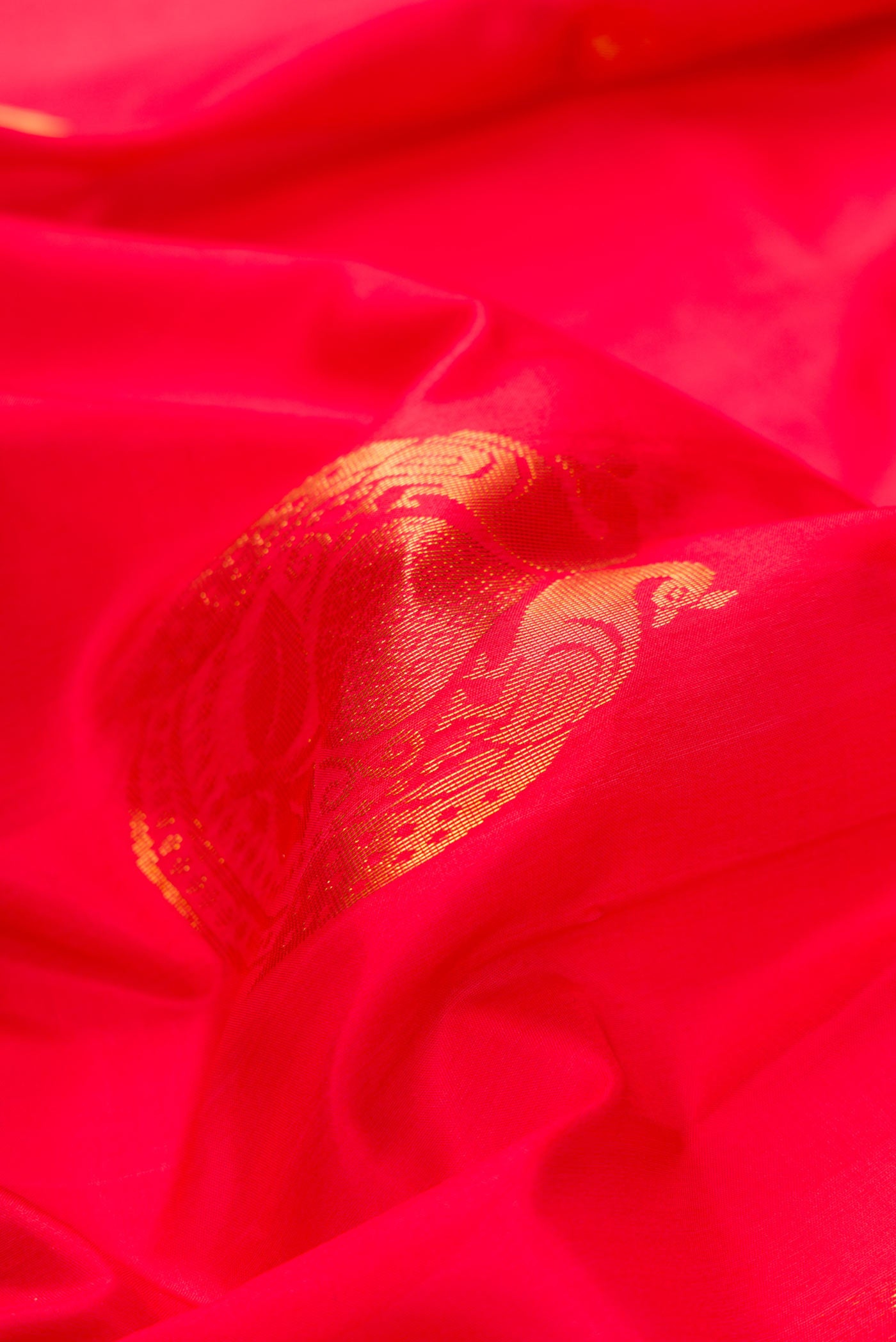 Close up of Red Dual Tone Soft Silk Saree with Zari Butta on the body and Zari Border.  displaying folds
