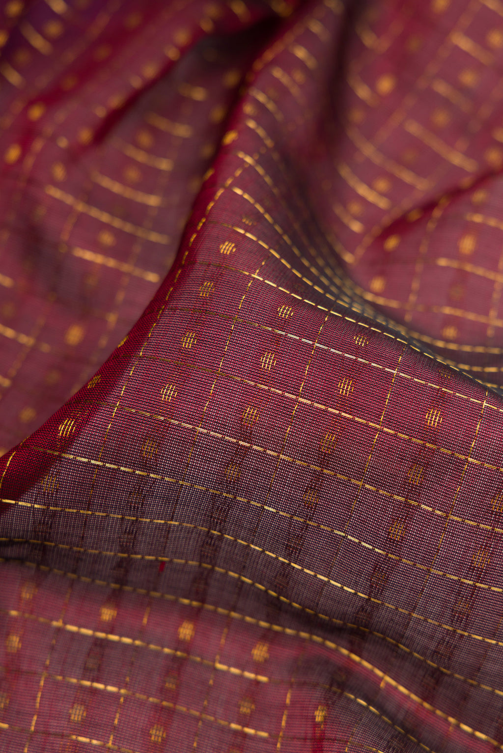 Close up of Maroon Silk Cotton Saree with Checked design on the body and Zari Border.  displaying folds
