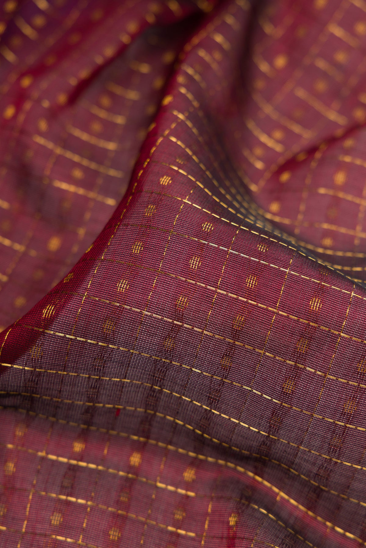 Close up of Maroon Silk Cotton Saree with Checked design on the body and Zari Border.  displaying folds