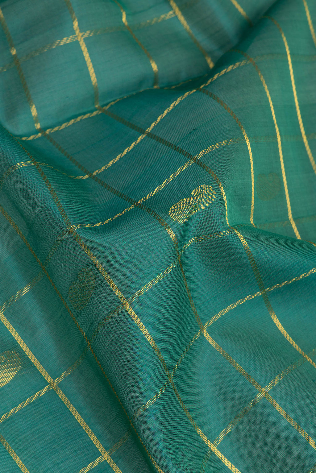 Close up of Green Silk Cotton Saree with Checked design on the body and Zari Border.  displaying folds