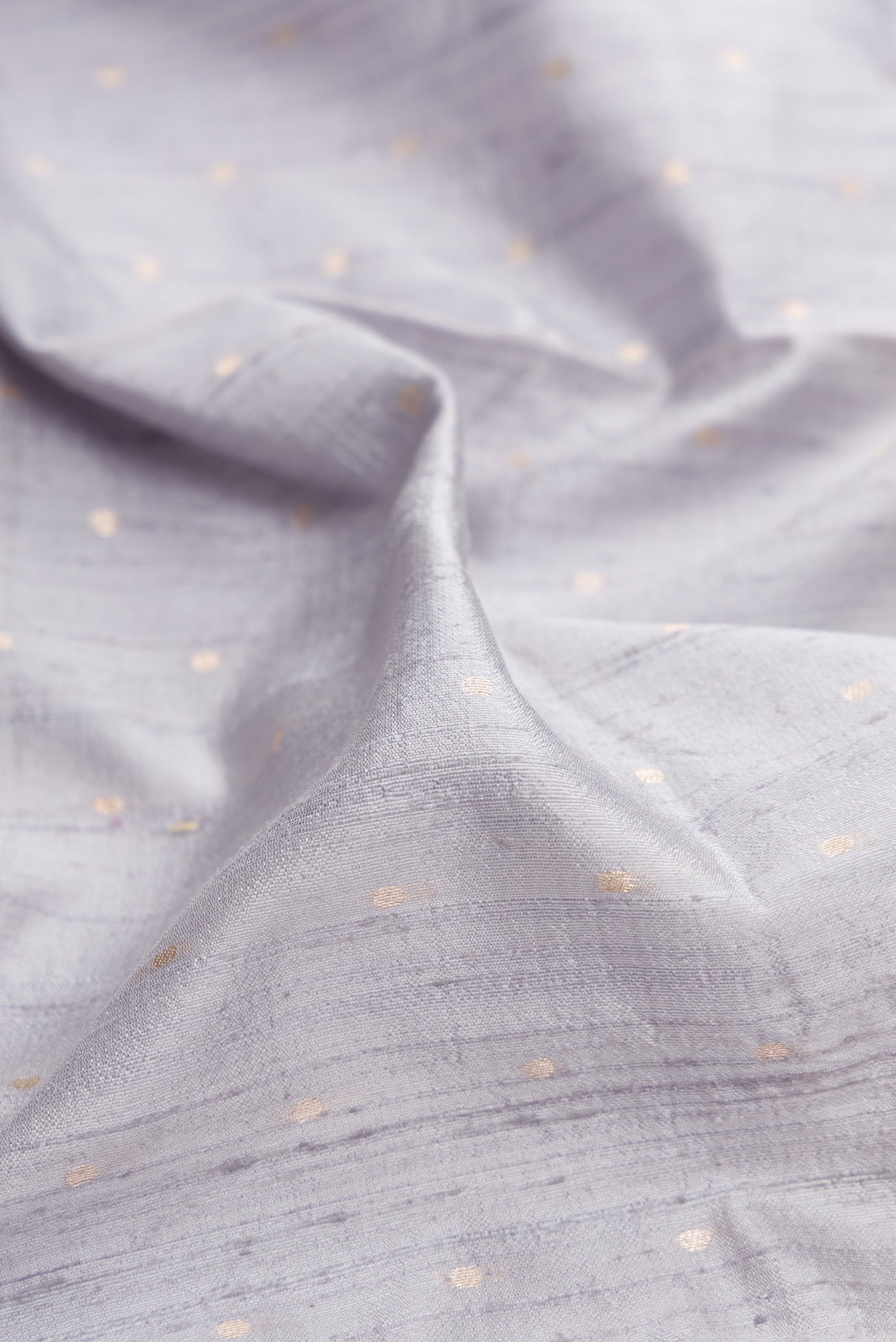 Close up of Grey Dual Tone Banarasi Silk Saree with Zari Butta on the body and Zari Border.  displaying folds